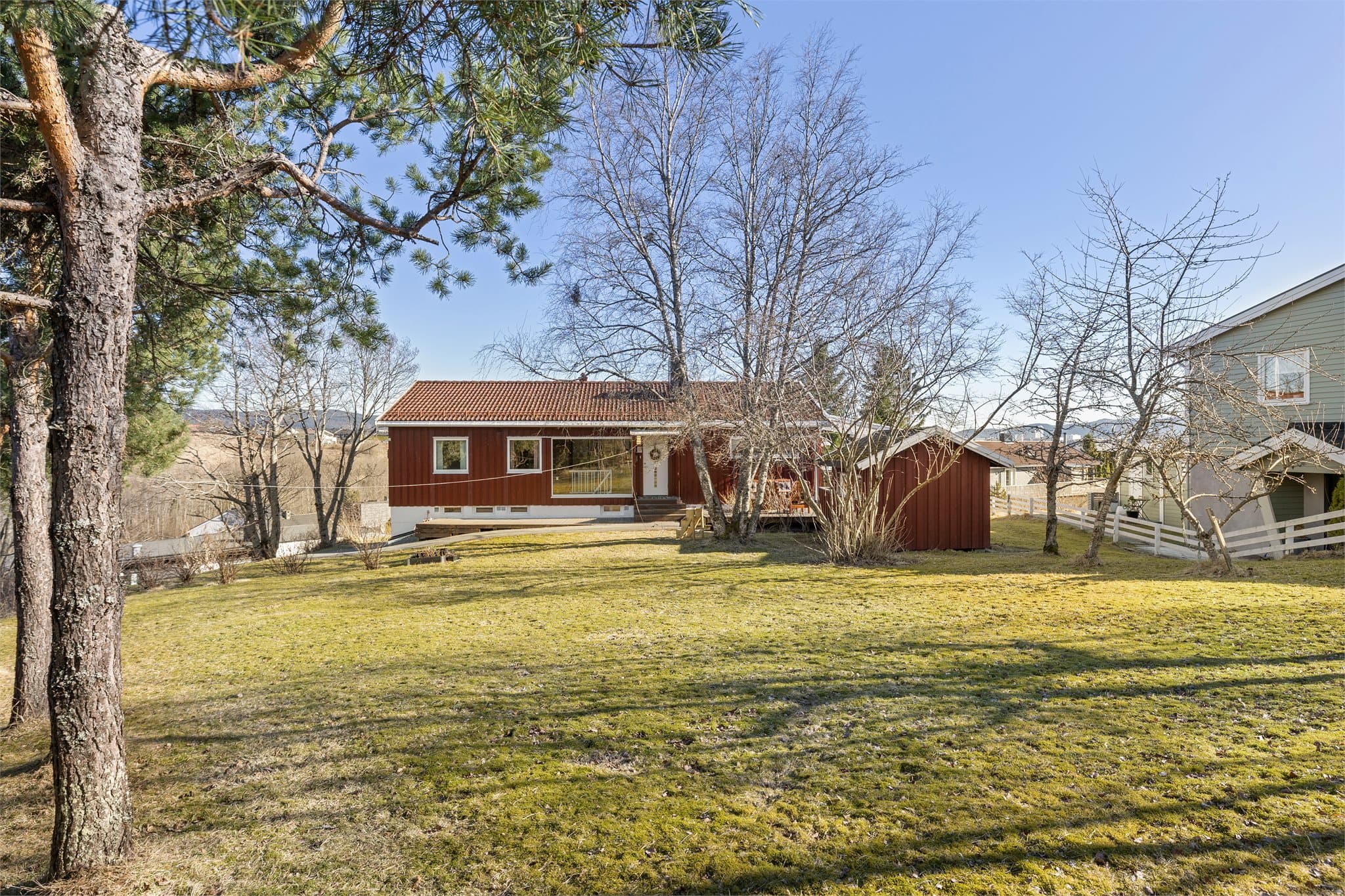 Eiendommen har en stor og flott hage med rikelig boltreplass for hele familien, perfekt for lek og aktivitet.