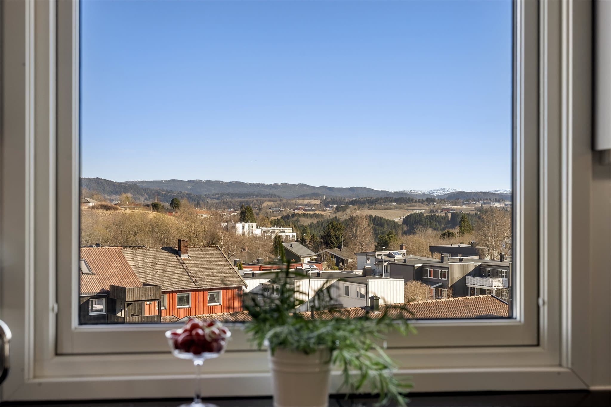 Fra kjøkkenet har man flott utsikt mot nærliggende boliger og naturområder.