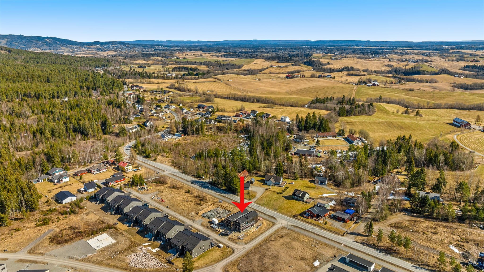 Umiddelbar nærhet til bussholdeplass og kort vei til skoler og barnehager. Bilde tatt før bygg ved siden er satt opp.