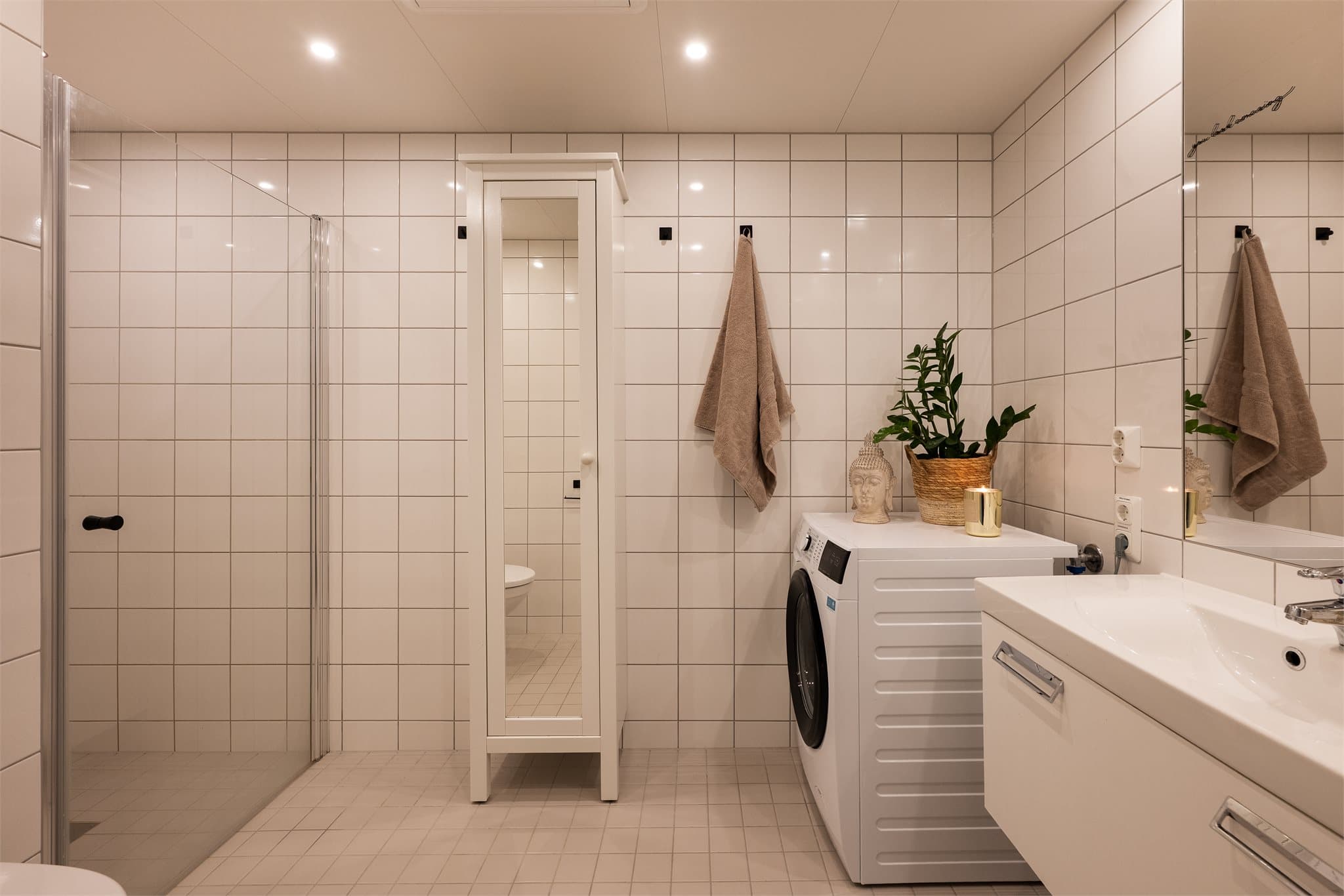 Tidløst baderom med gulvvarme og downlights i himling.