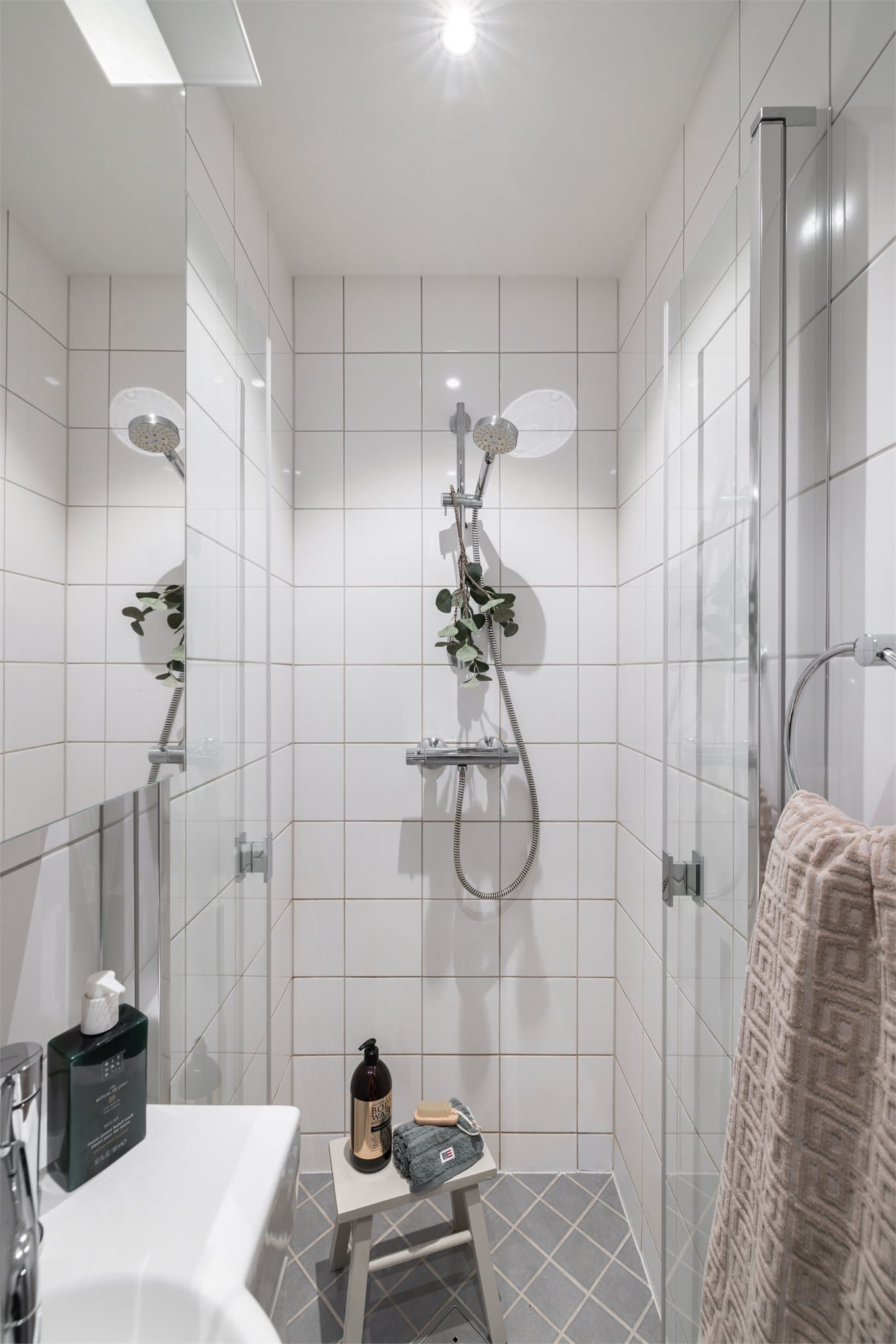 Dusjhjørne med svingdør, sluk i sone, håndholdt dusjhode og termostatstyrt blandebatteri. Veggmontert toalett.