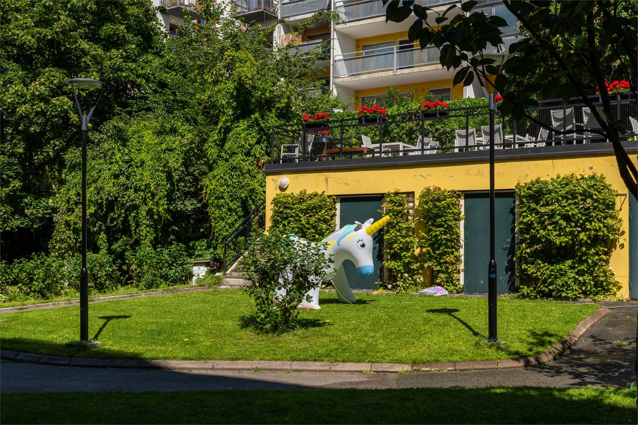 Pent opparbeidet med internveier, belysning, plen og trær.