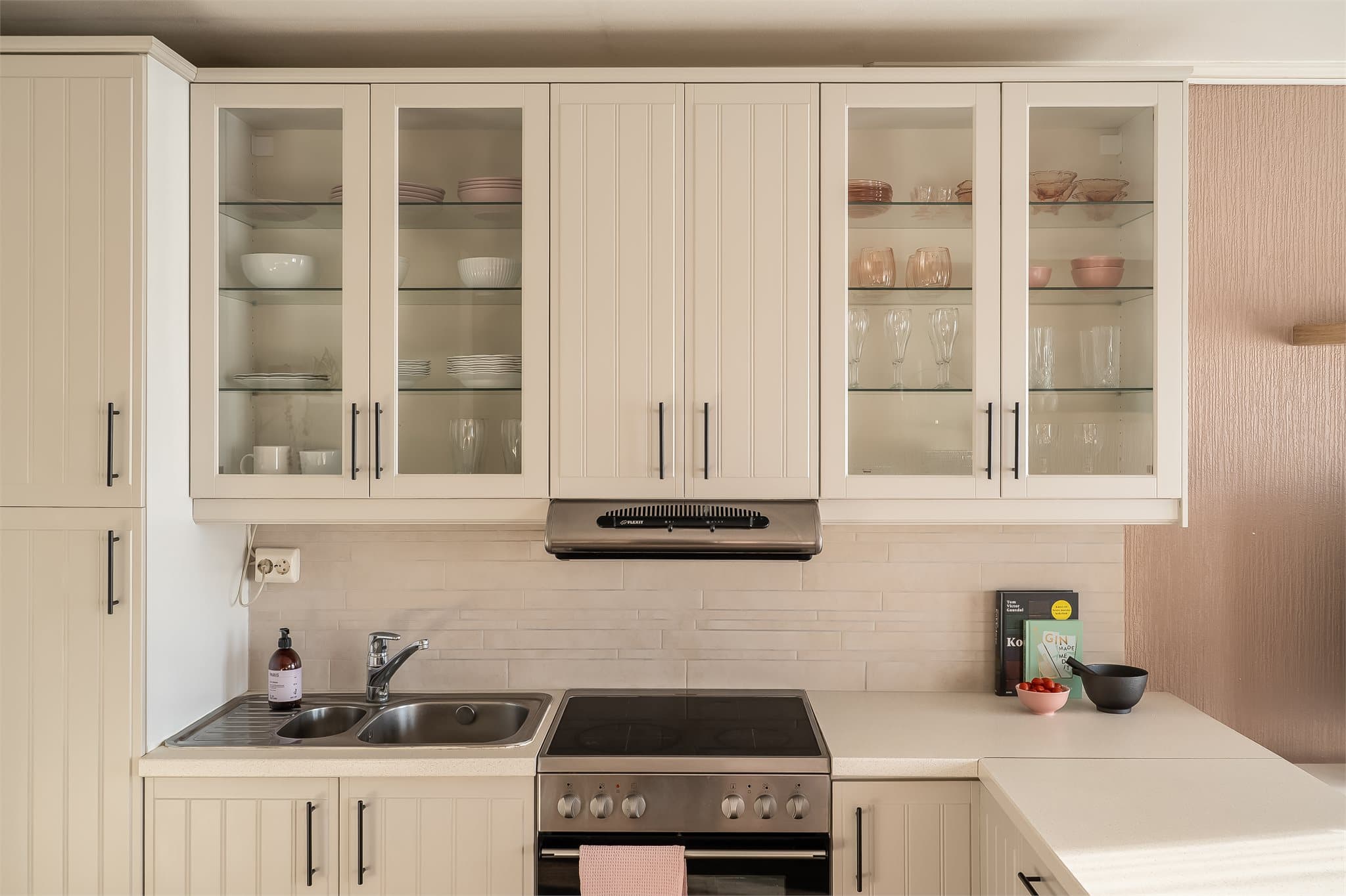 Tidløse fronter med vitrineskap og godt med oppbevaringsplass.