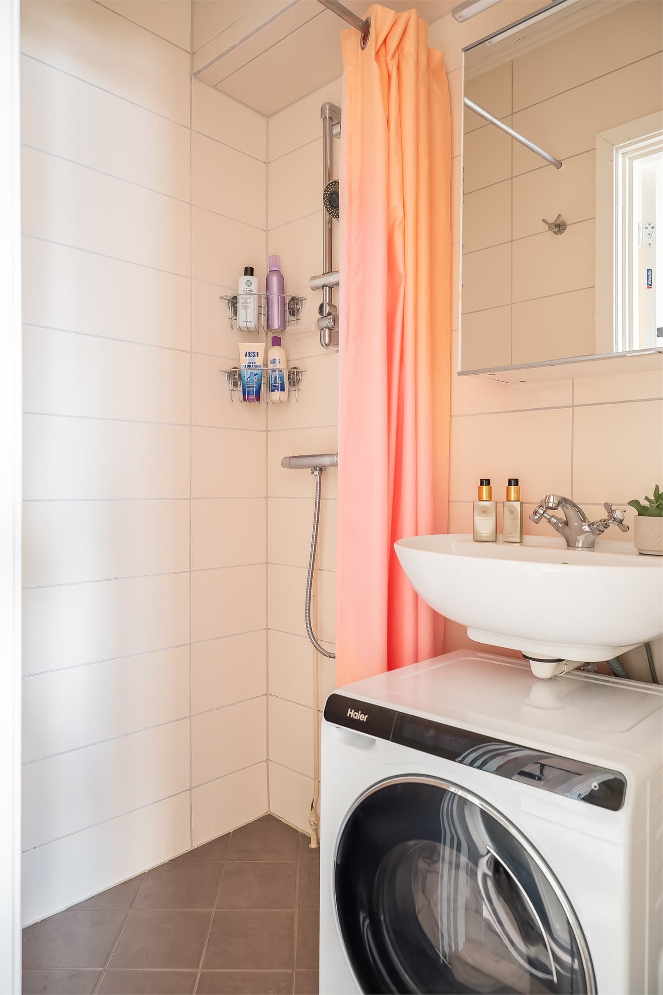 Flislagt bad med dusj og opplegg for vaskemaskin.