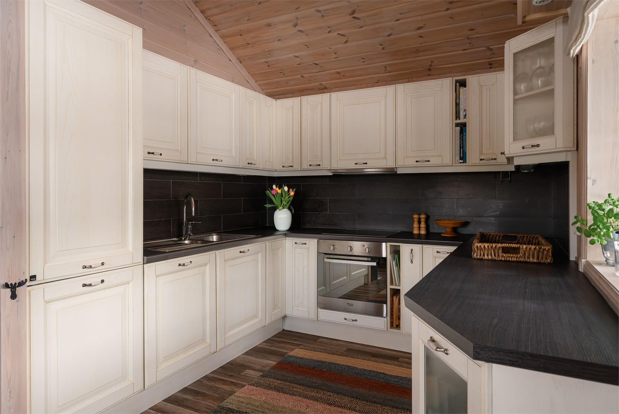 Kjøkkenet har rikelig med oppbevaringsplass i skap og skuffer, og er utstyrt med integrert stekeovn, platetopp, oppvaskmaskin og kombiskap med kjøl og frys.