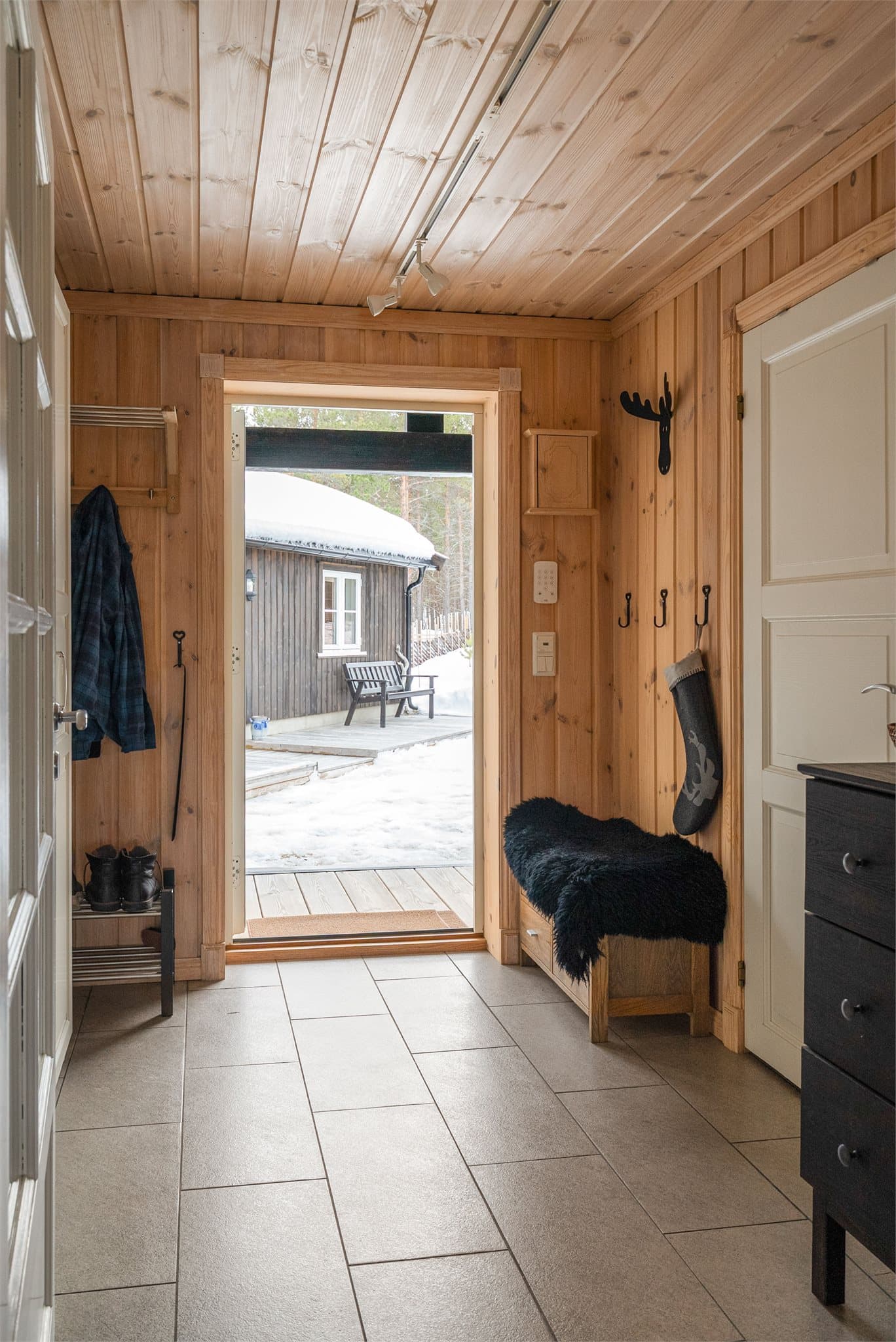 Flislagt entre med varmekabler og store garderobeskap.