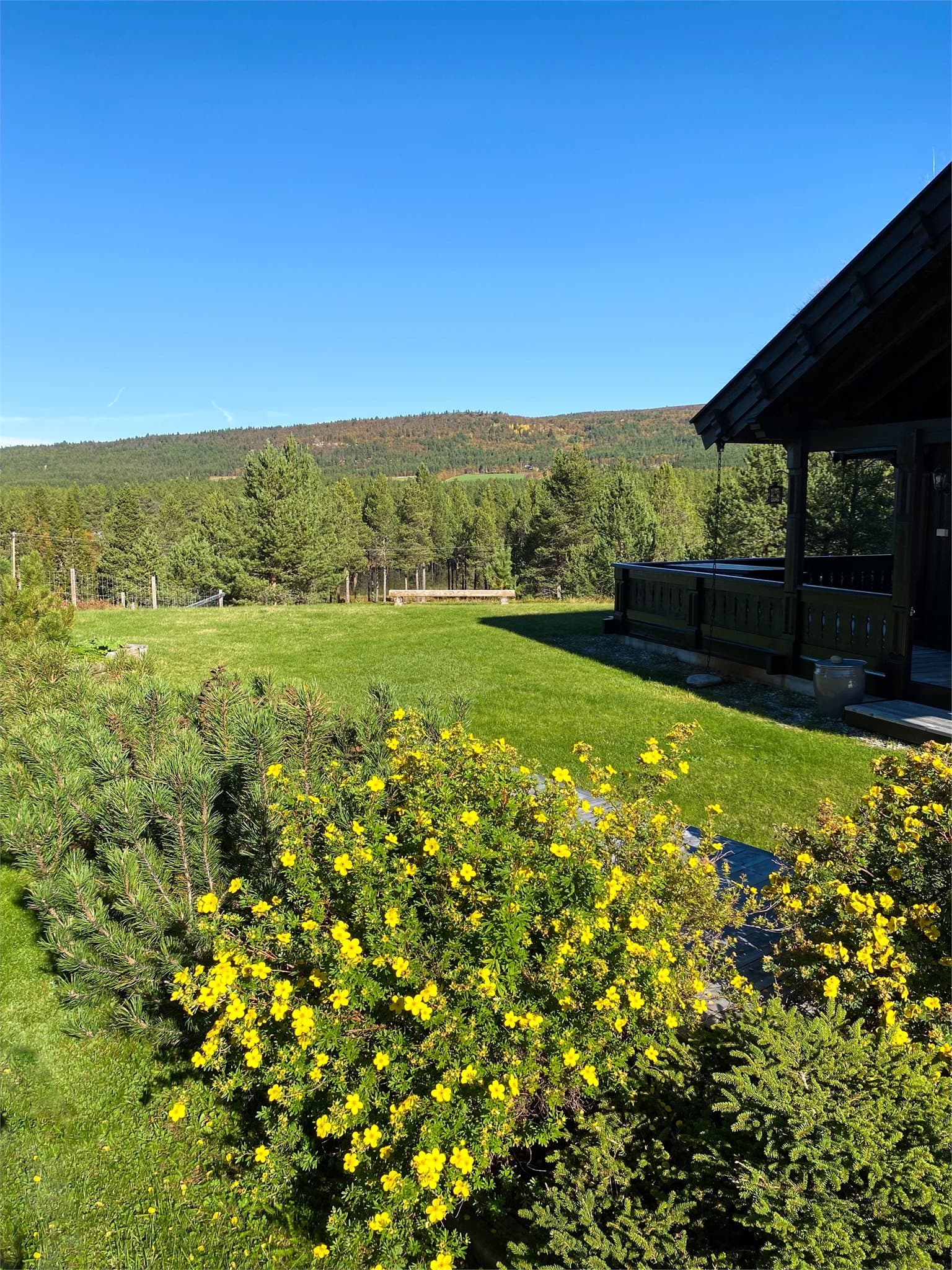 Privat bilde fra selger som viser eiendommen i sommerhalvåret, med flott utsikt over naturskjønne omgivelser.