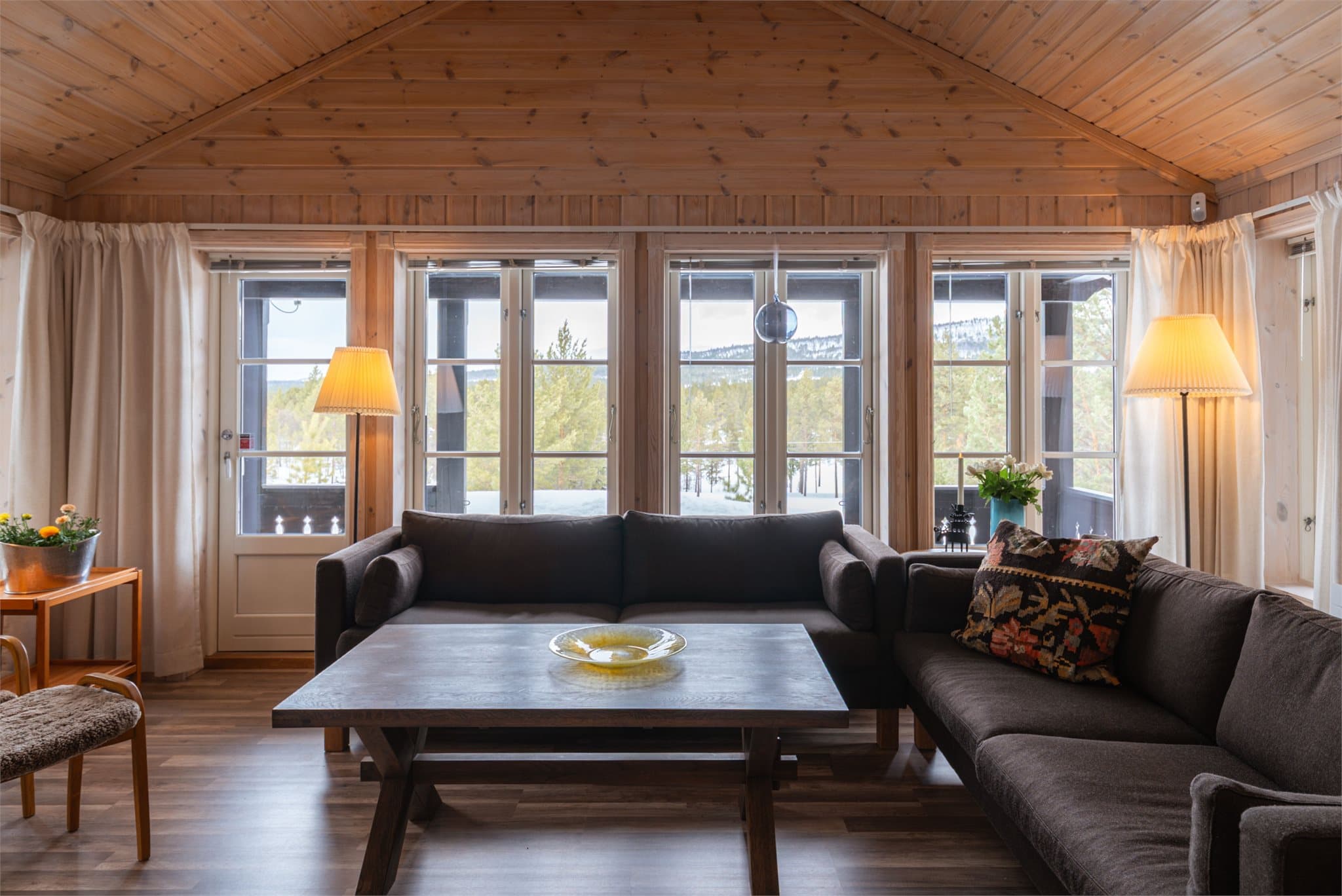 Fra stuen er det utgang til en stor og solrik terrasse som strekker seg rundt flere sider av hytten.