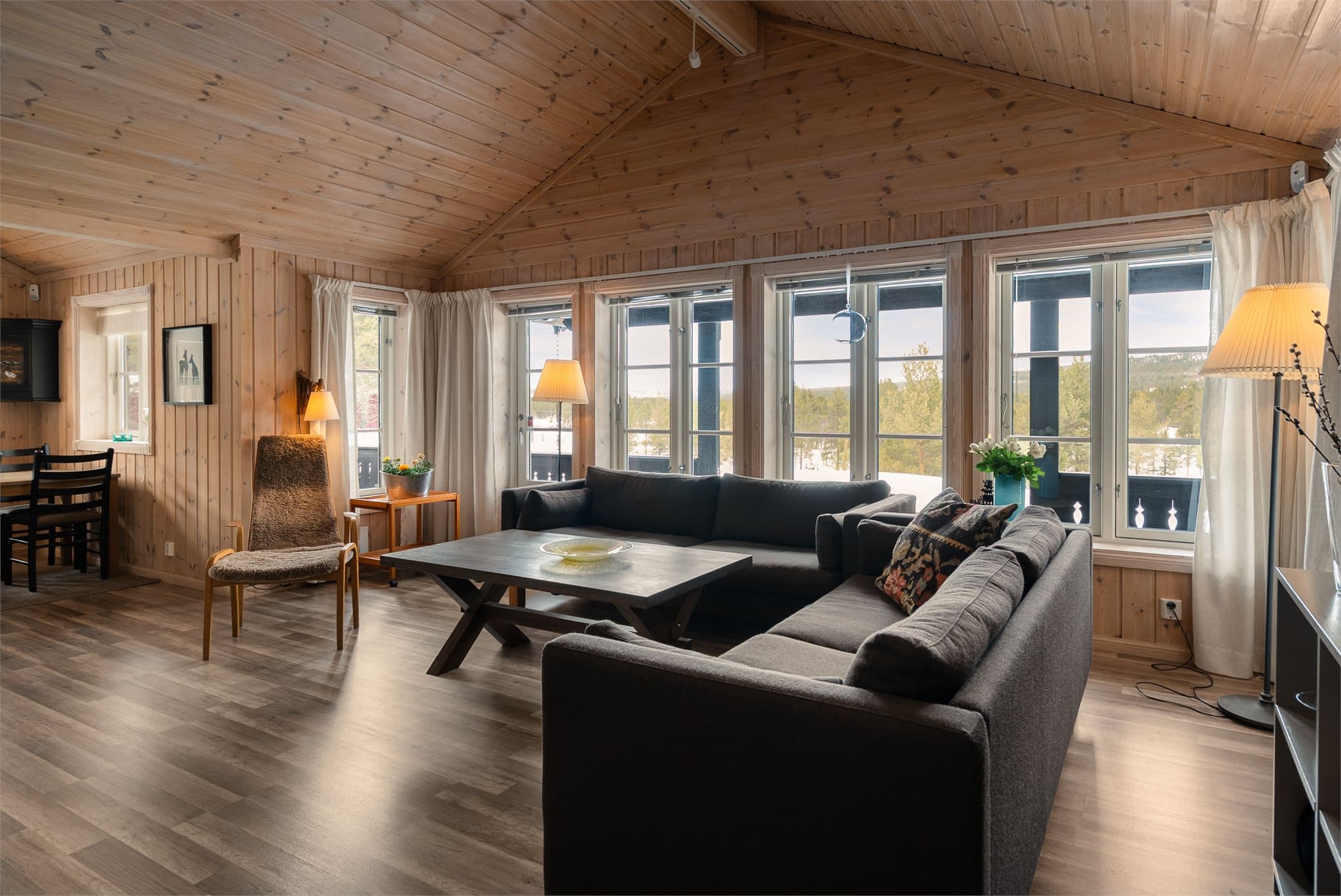 Med store vindusflater og god takhøyde fylles stuen av lys, og den luftige atmosfæren gjør rommet til et naturlig samlingspunkt for familie og venner.