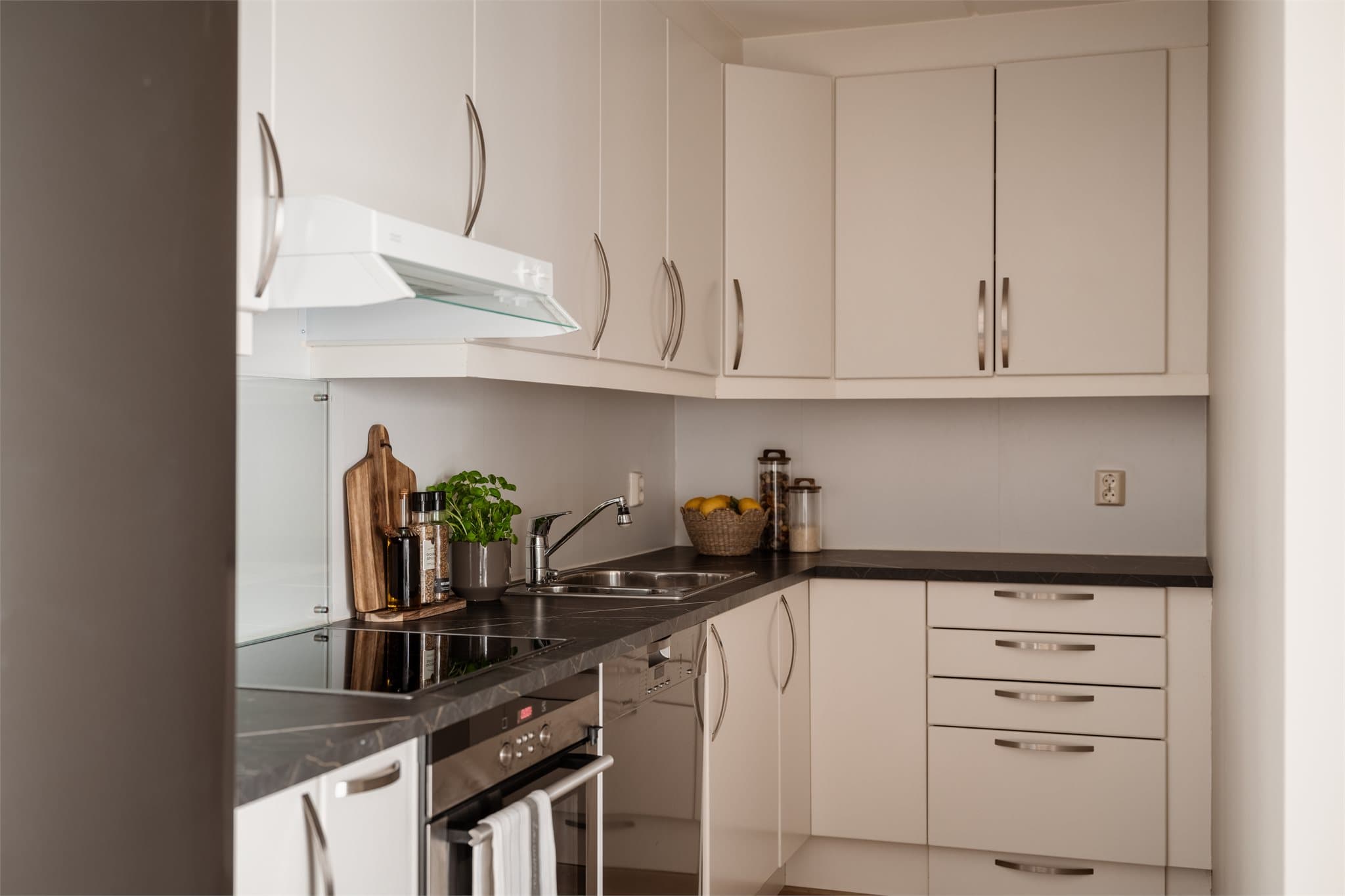 Kjøkkenet har en praktisk innredning med glatte fronter, integrert stekeovn og platetopp.