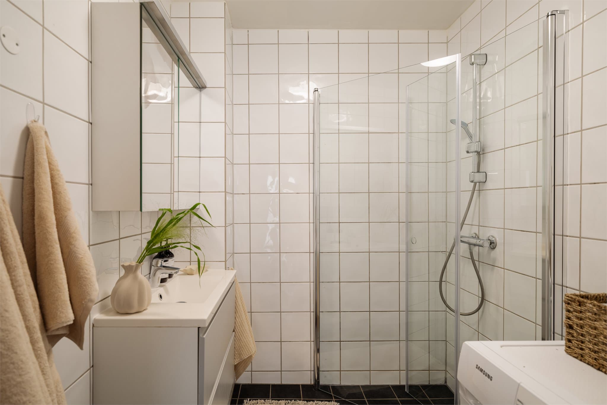 Flislagt bad/vaskerom med elektriske varmekabler i gulvet og mekanisk avtrekk.