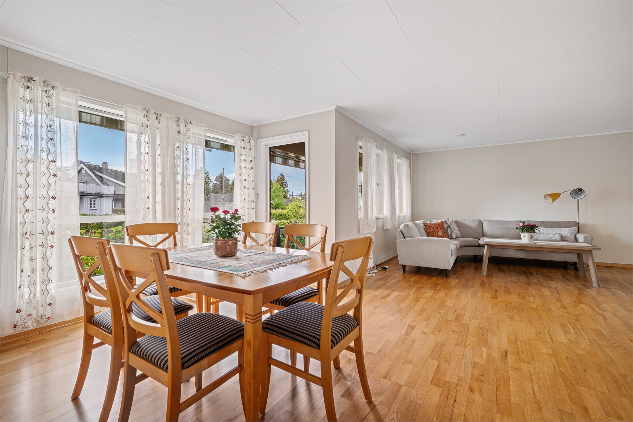 Fra stuen er det utgang til en nyere veranda med moderne glassfasade-rekkverk – perfekt for å forlenge oppholdsrommet ut i det fri på fine dager.