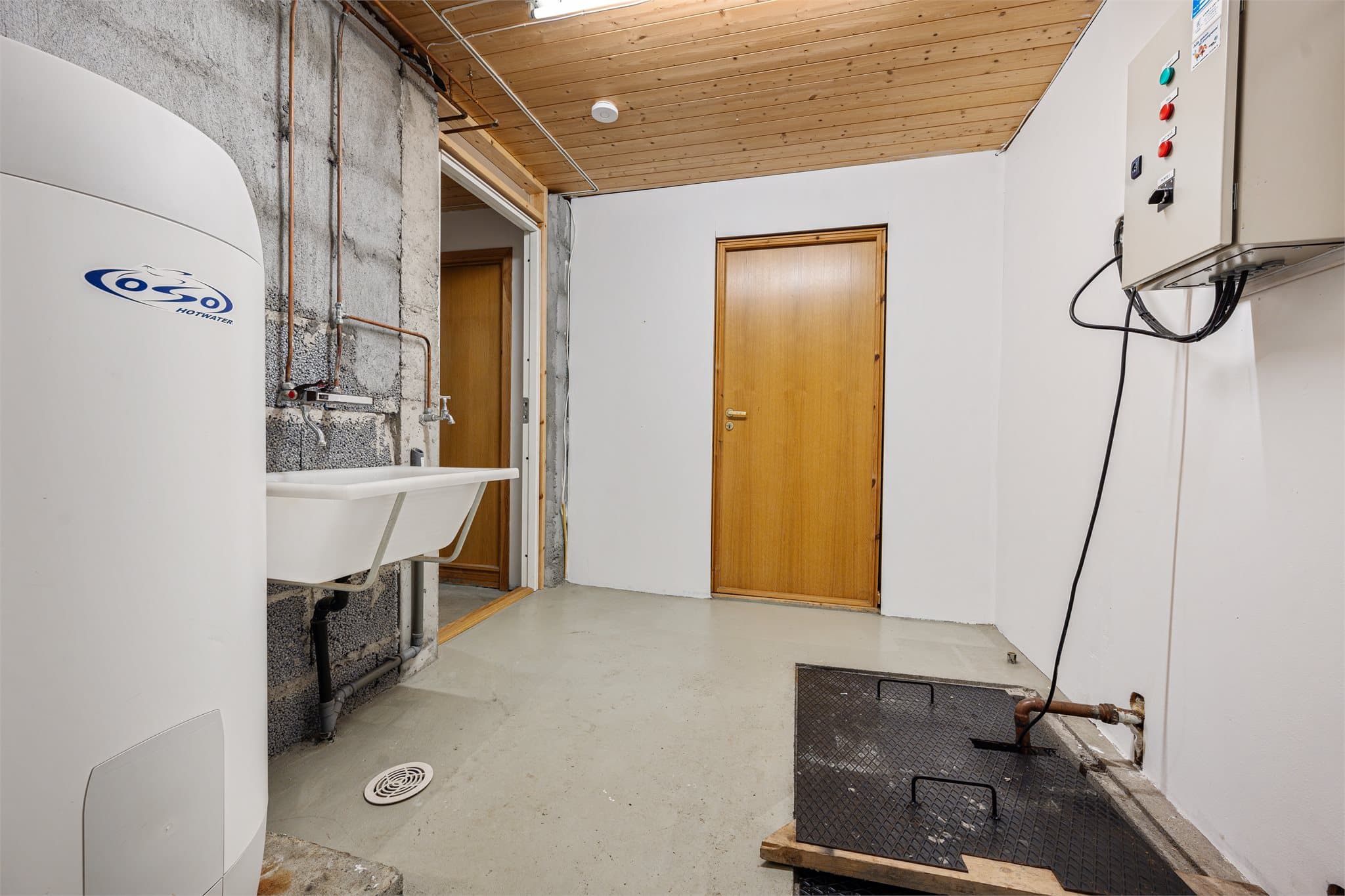 Vaskerommet har en funksjonell utforming og er utstyrt med grunnvannspumpe plassert i kum i gulvet. Et praktisk birom i kjelleren med tekniske installasjoner og gode muligheter for organisering og oppbevaring.
