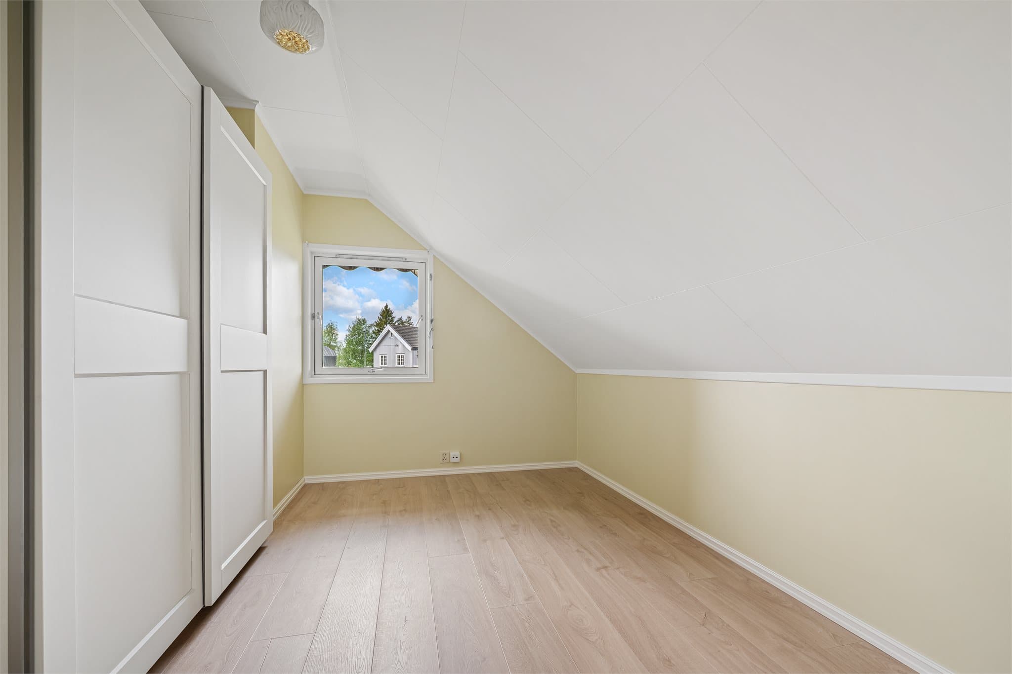 Soverom 2 og 3 i loftsetasjen fremstår lyse og innbydende med moderne 1-stavs laminatgulv og malte veggflater i rolige fargetoner. Begge soverommene har praktiske skyvedørsgarderober som gir gode oppbevaringsmuligheter og effektiv utnyttelse av rommene.