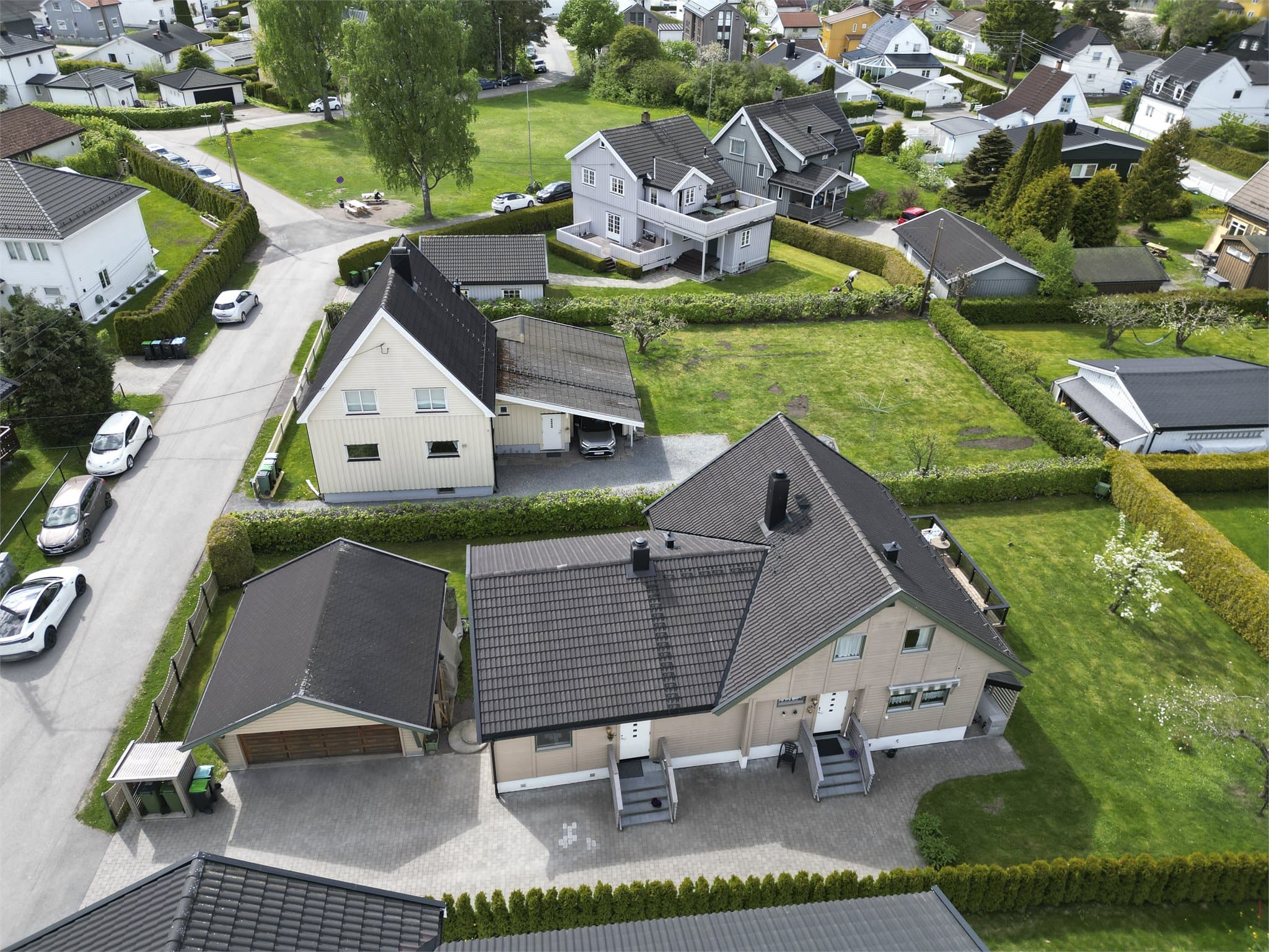 Droneperspektivet fremhever boligens fine plassering i rolige omgivelser med kort vei til sentrum, skoler, barnehager og kollektivtransport.