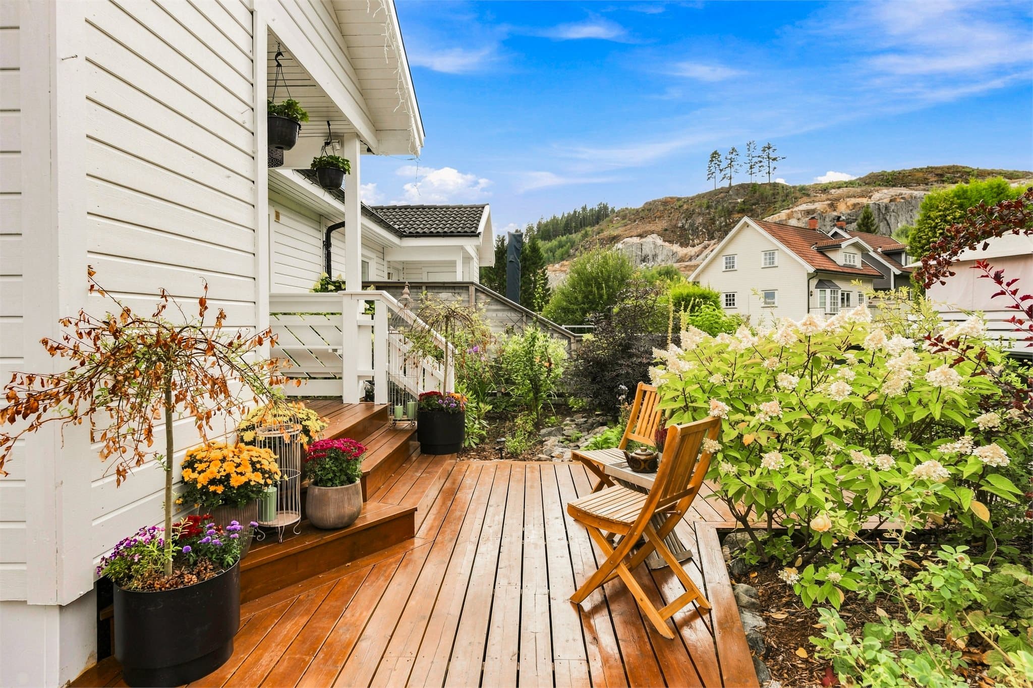 Hyggelig uteområde med terrasse og frodig beplantning – en lun plass for morgenkaffen eller rolige sommerdager.