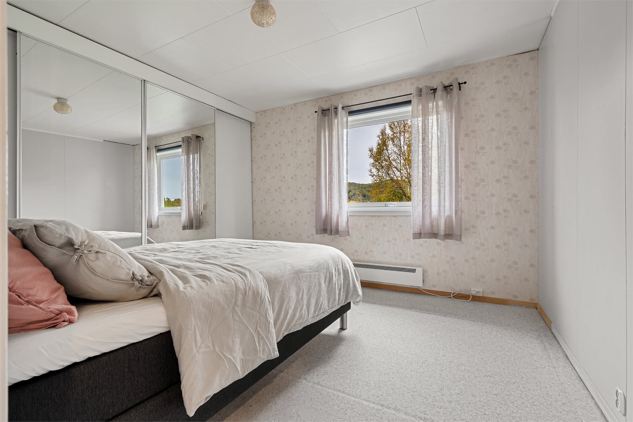Hovedsoverom med heldekkende skyvedørsgarderobe og speildører.