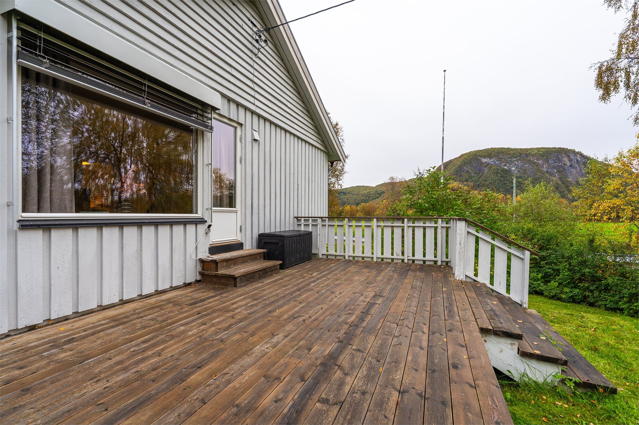 Utgang fra stuen til den store verandaen med trappetrinn ned til hagen.