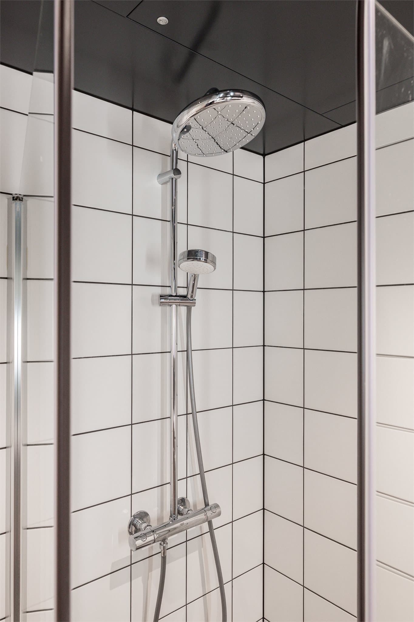 Dusjhjørne med glassdører og regnfallsdusj.