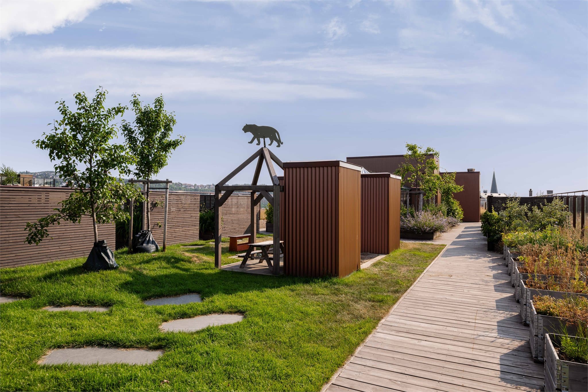 Sameiets takterrasse er et flott tillegg – opparbeidet med sittegrupper, blomsterbed og drivhus, og gir beboerne en hyggelig felles møteplass med gode solforhold og utsikt over nærområdet.