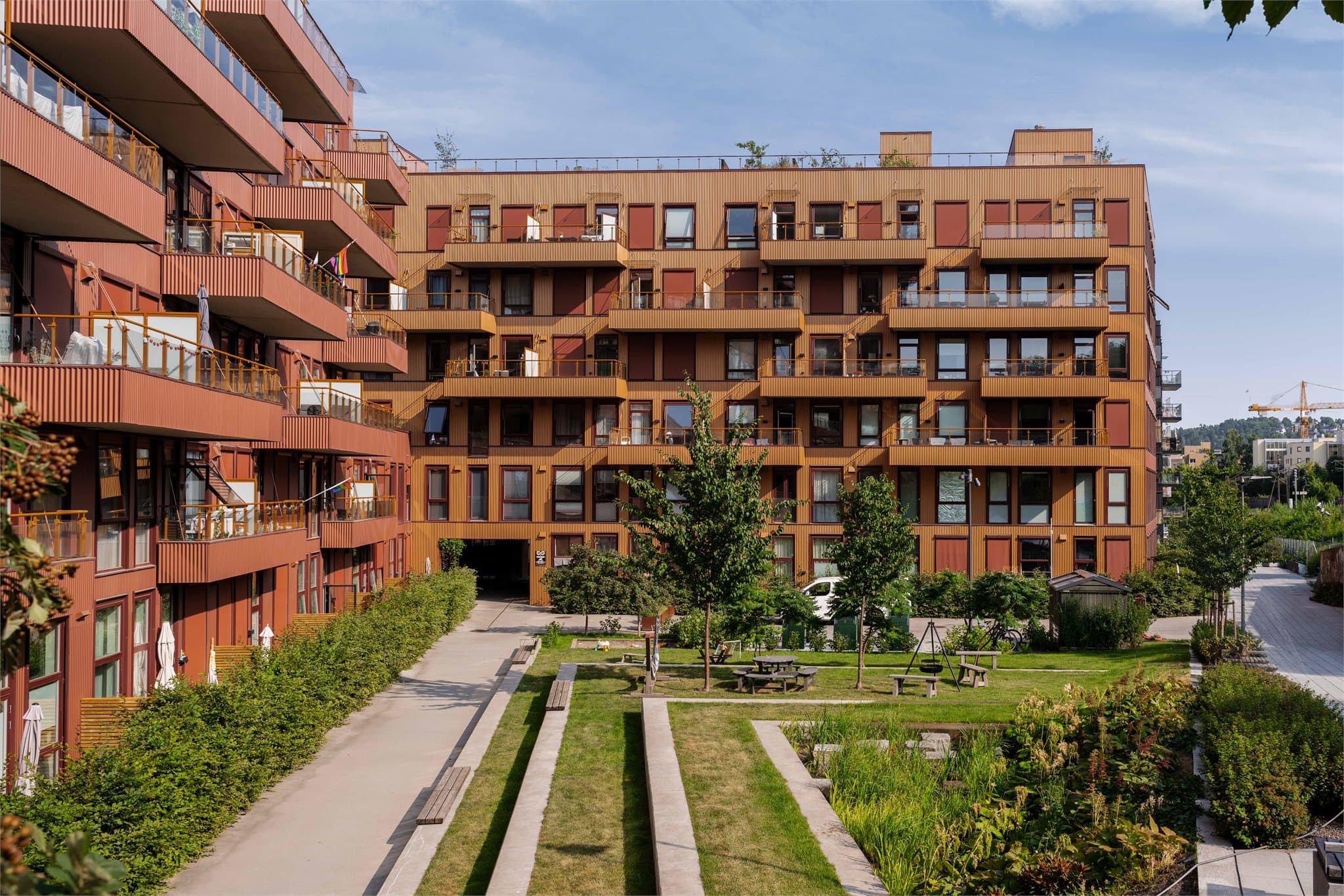 Eiendommen ligger i et veletablert boligkvartal med moderne blokkbebyggelse, pent opparbeidede fellesarealer og grønne soner mellom byggene.