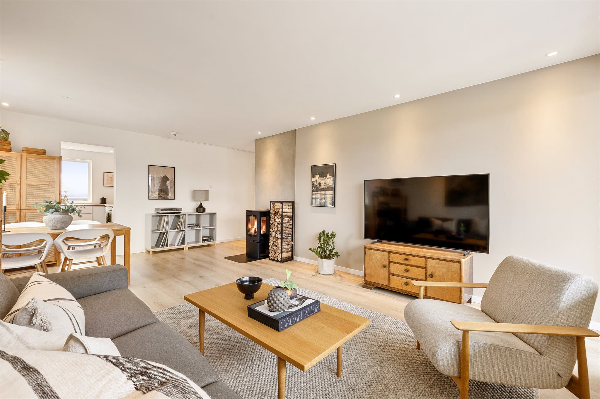 Innbydende og romslig stue med moderne peis og god plass til både sofagruppe og spiseplass.