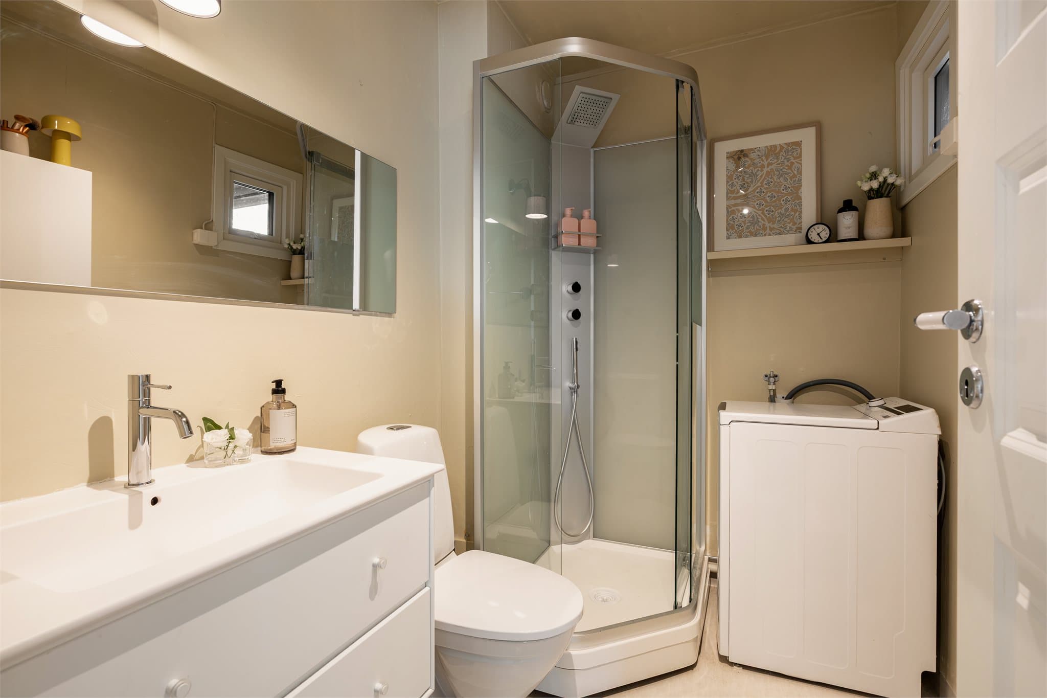 Baderommet har dusjkabinett og opplegg for vaskemaskin.