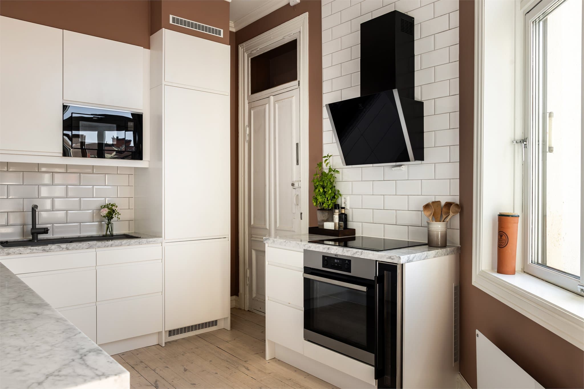 Kjøkkenet er utstyrt med integrerte hvitevarer som induksjonstopp, vinskap, oppvaskmaskin, mikrobølgeovn og stekeovn.