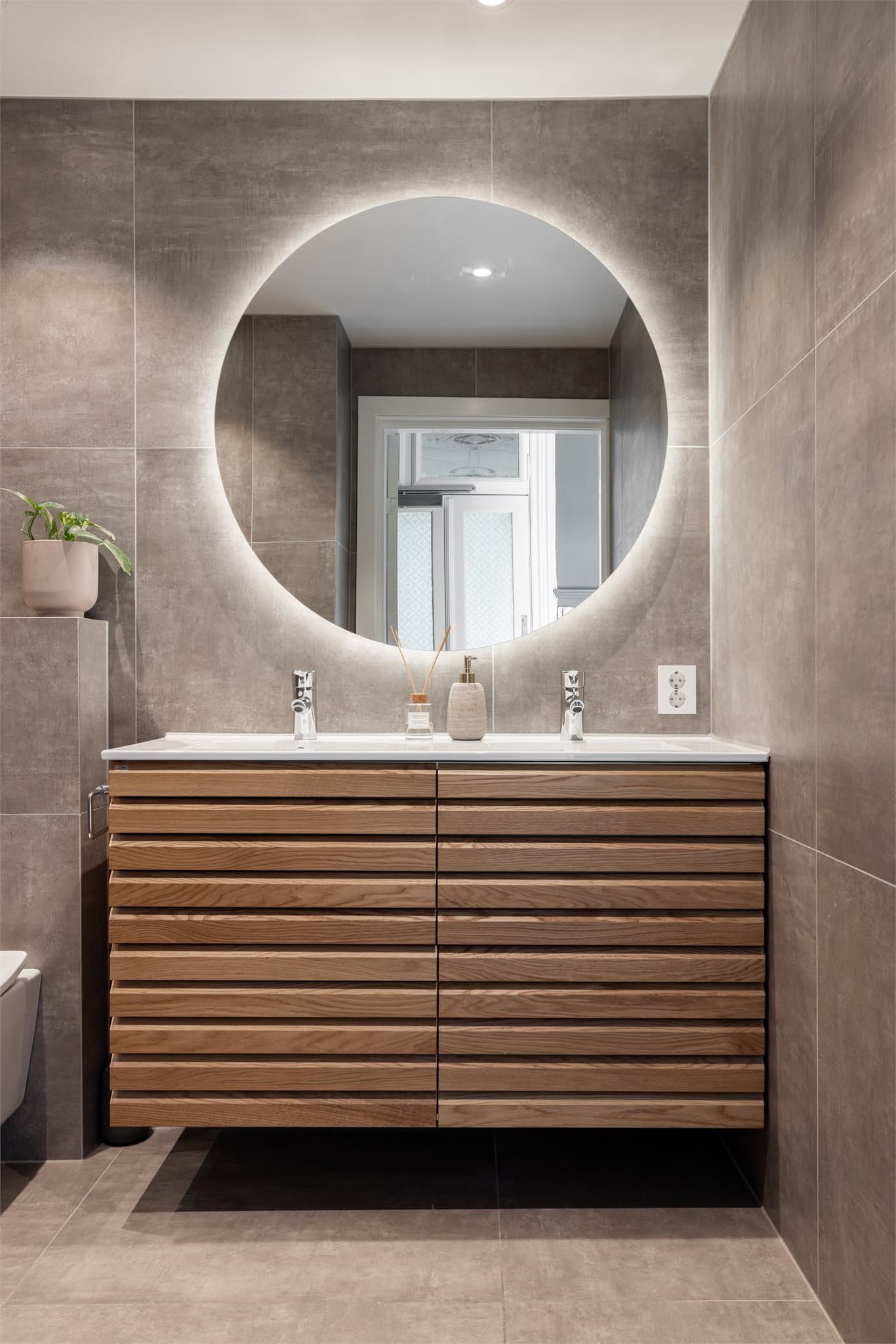 Her er det en dobbel servant med god oppbevaringsplass og et stort, bakbelyst speil.