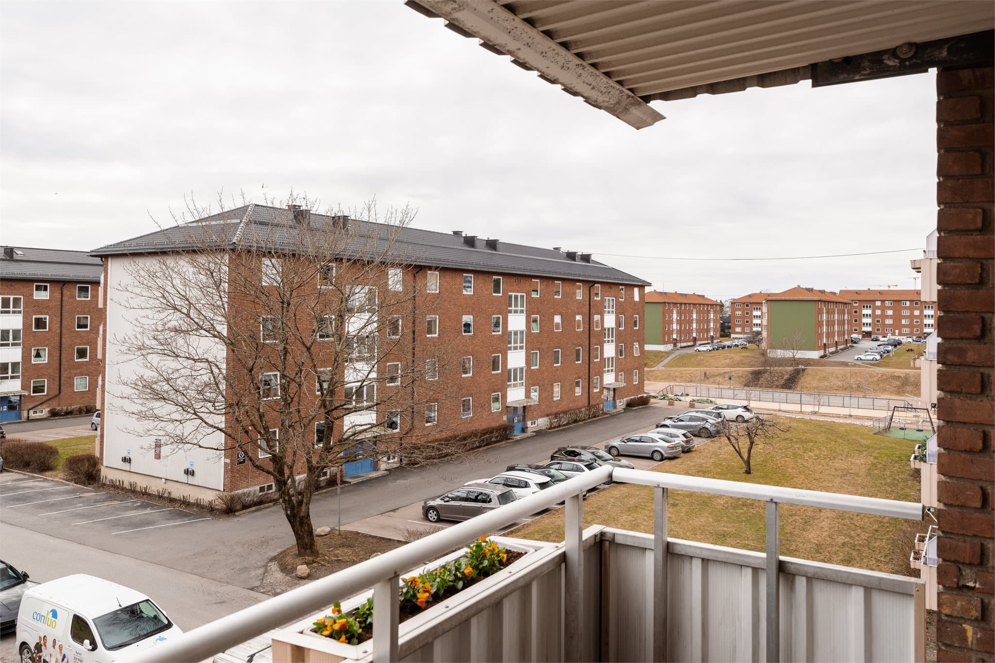 Fra balkongen ser man ut over borettslagets rolige og grønne fellesområder.