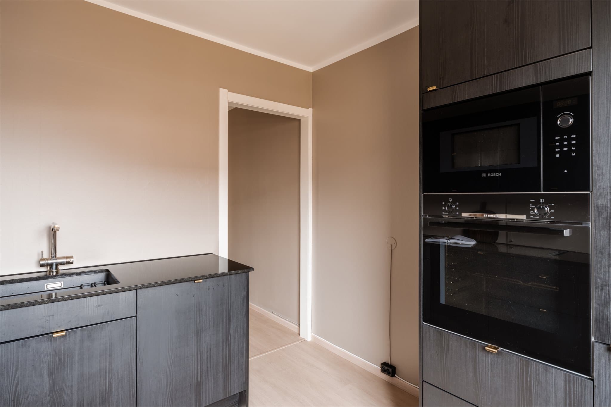 Integrert stekeovn og mikrobølgeovn i praktisk arbeidshøyde.