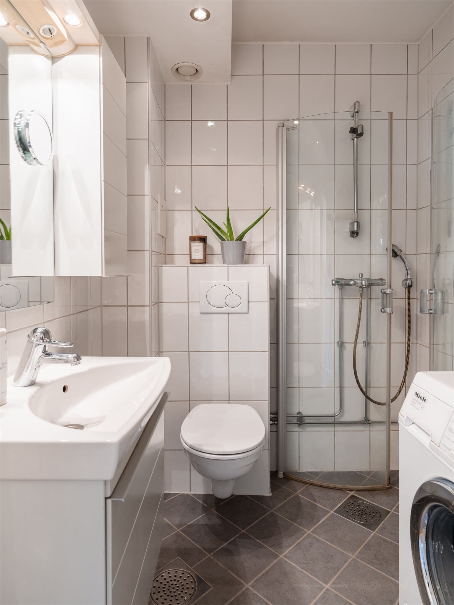 Flislagt bad med elektrisk gulvvarme, vegghengt klosett og opplegg for vaskemaskin. Badet er tatt i 2014 (i regi borrettslaget)