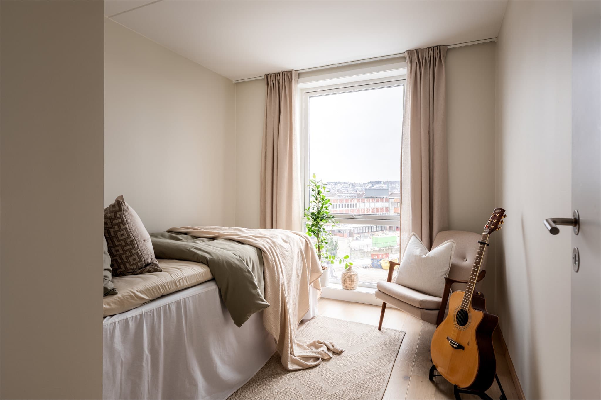 Leilighetens tredje soverom er romslig med mye lys fra det store vinduet.