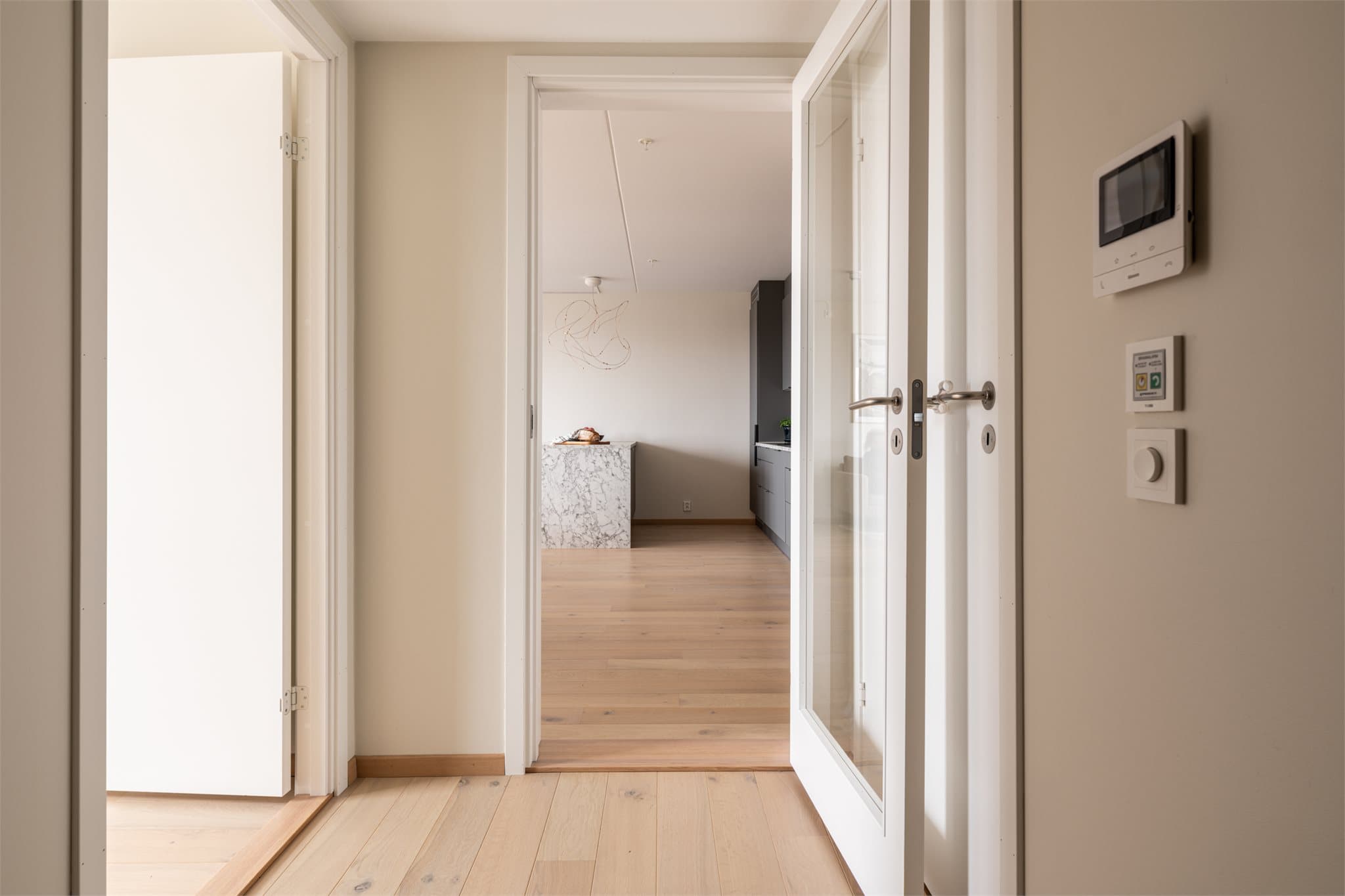 Vi tar turen inn igjen - oppholdsrommet er adskilt fra resten av leiligheten med en stilren glassdør.