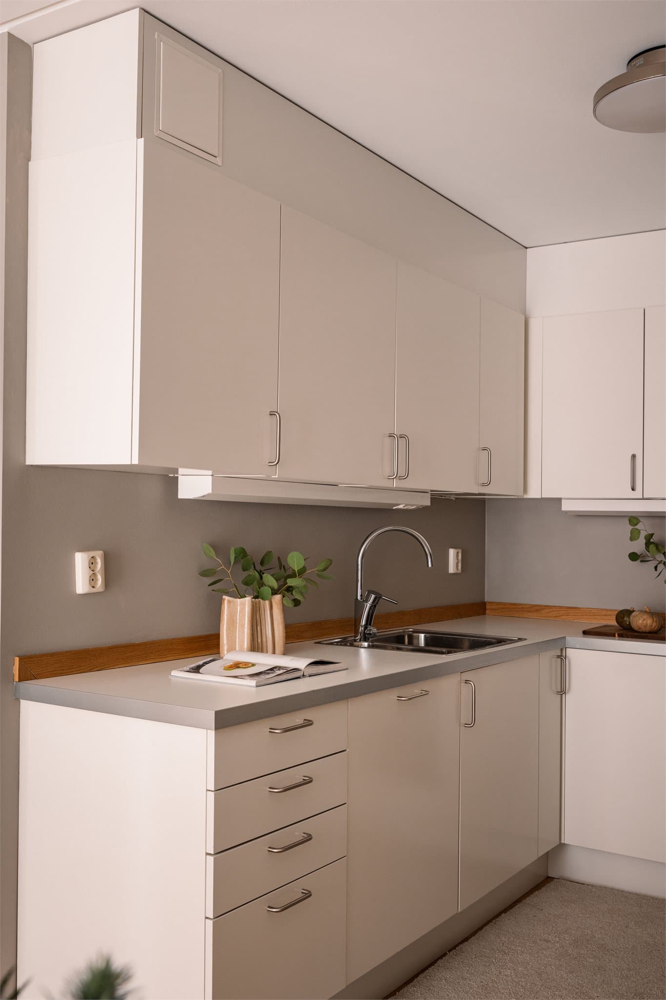 Kjøkkeninnredning fra 2010 med glatte fronter og benkeplate i laminat.