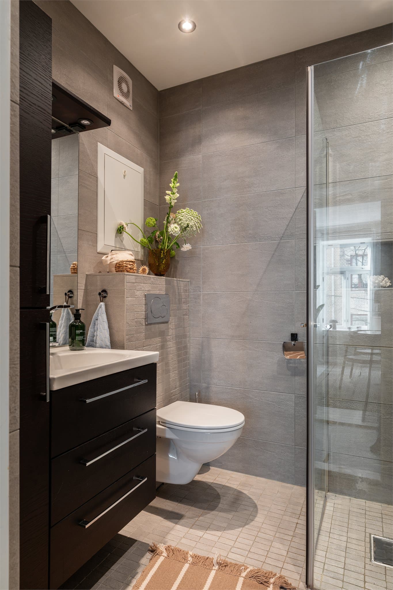 Badet er helfliset og har vegghengt toalett.