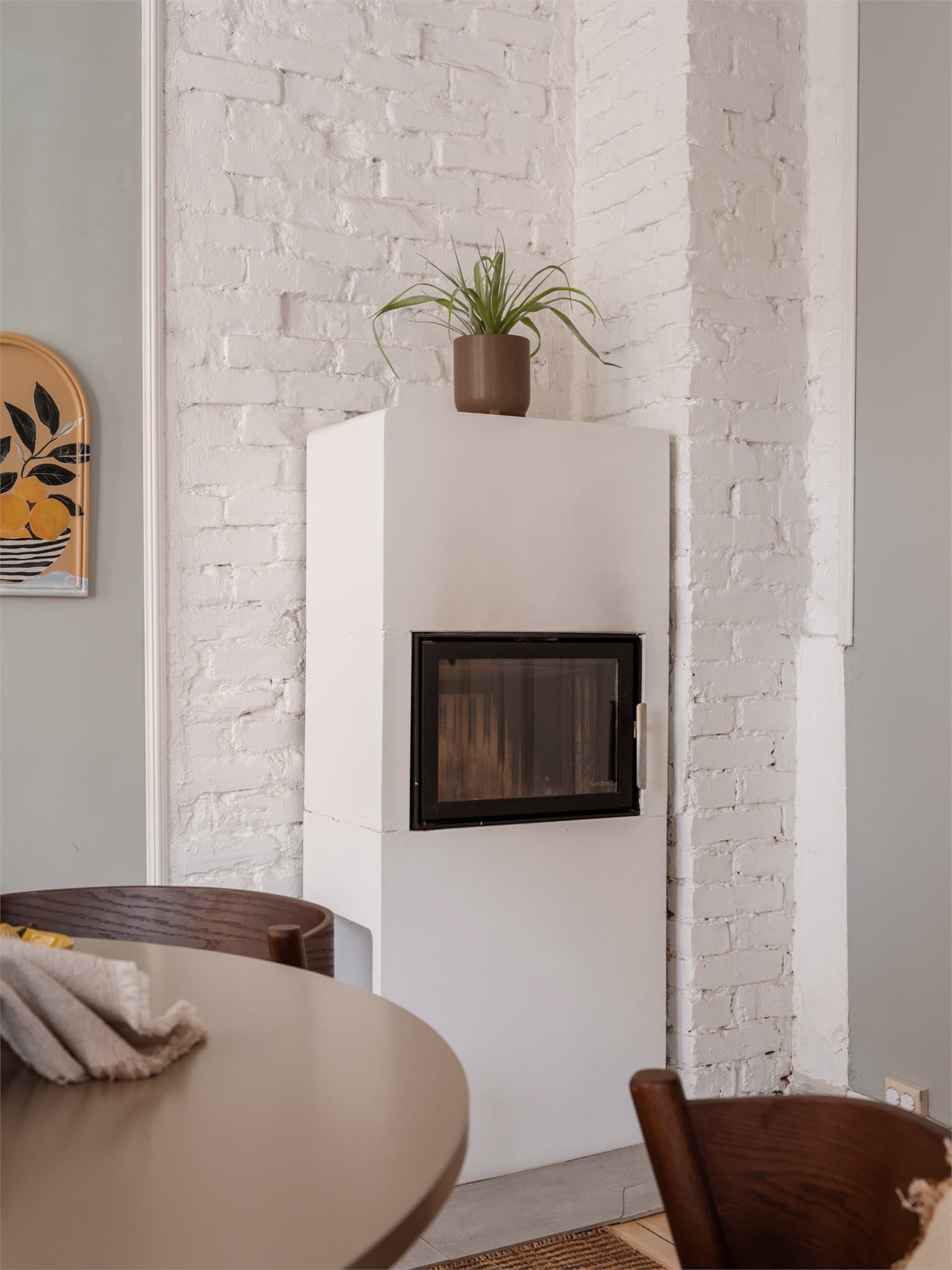 Peisovnen er plassert mot en eksponert teglsteinsvegg.