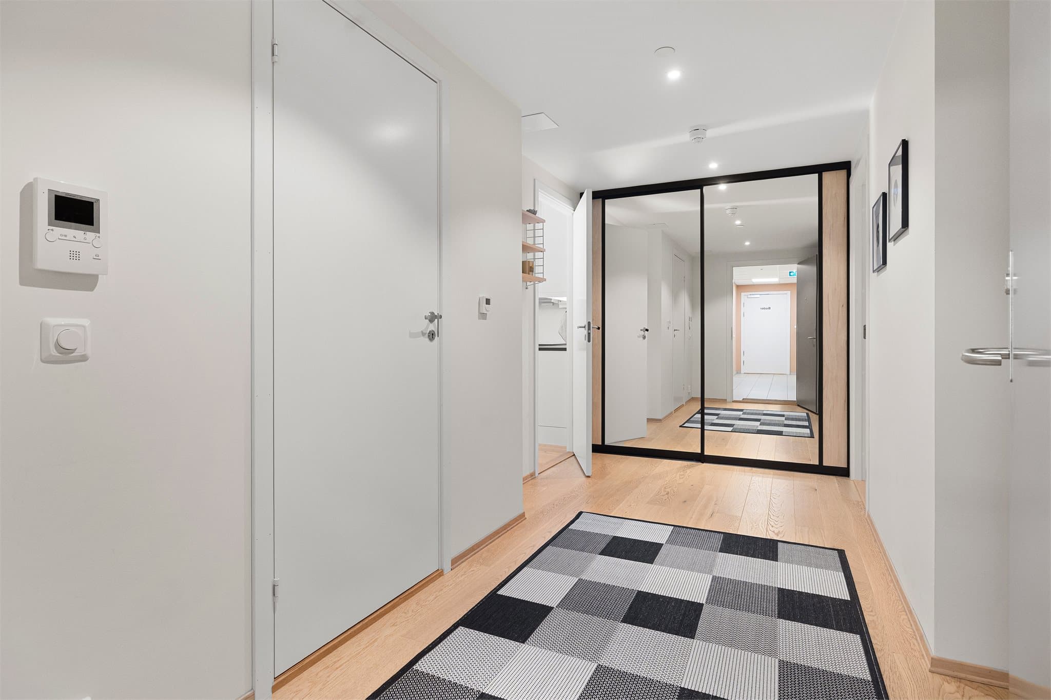 I entréen er det bygd skyvedørsgarderobe med speil og detaljer i lyst tre.