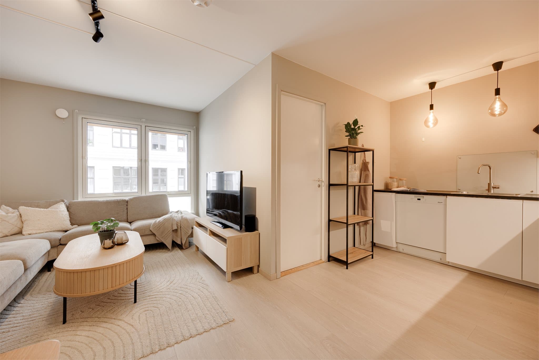 Stuen oppleves romslig og luftig, med store vindusflater som slipper inn rikelig med naturlig lys.