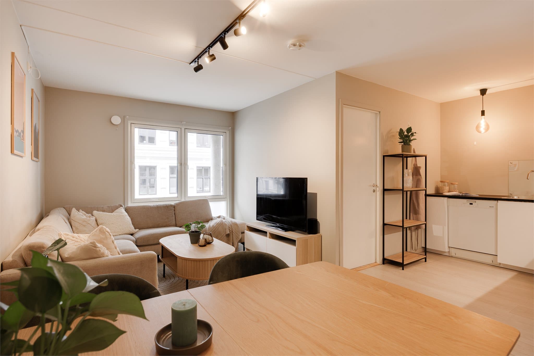 Den åpne løsningen mot kjøkkenet skaper et sosialt og hyggelig oppholdsrom med plass til både sofagruppe, mediemøblement og et større spisebord.