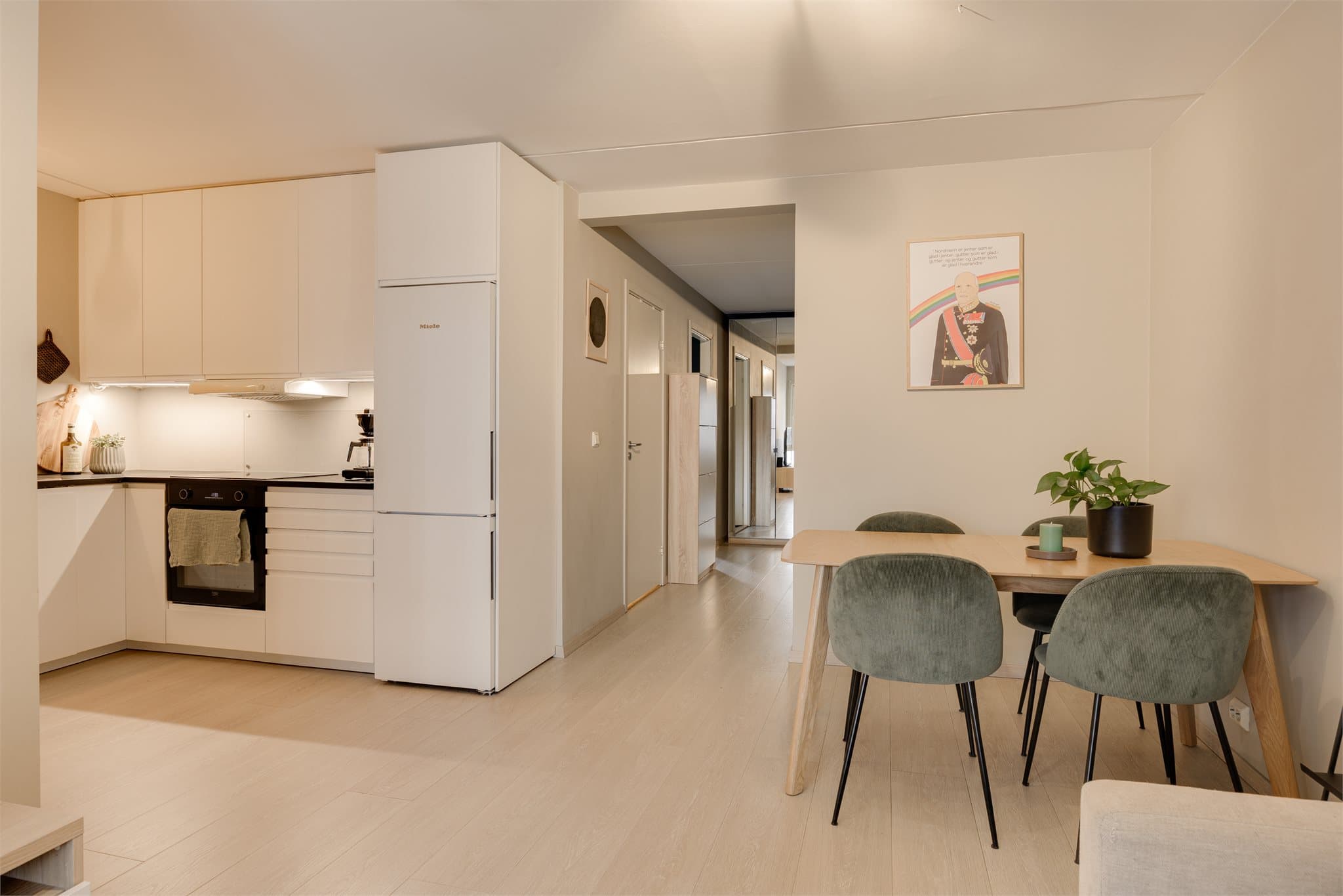 Den åpne løsningen mot stuen gjør kjøkkenet til en naturlig del av det sosiale allrommet, samtidig som det er funksjonelt og effektivt i bruk.