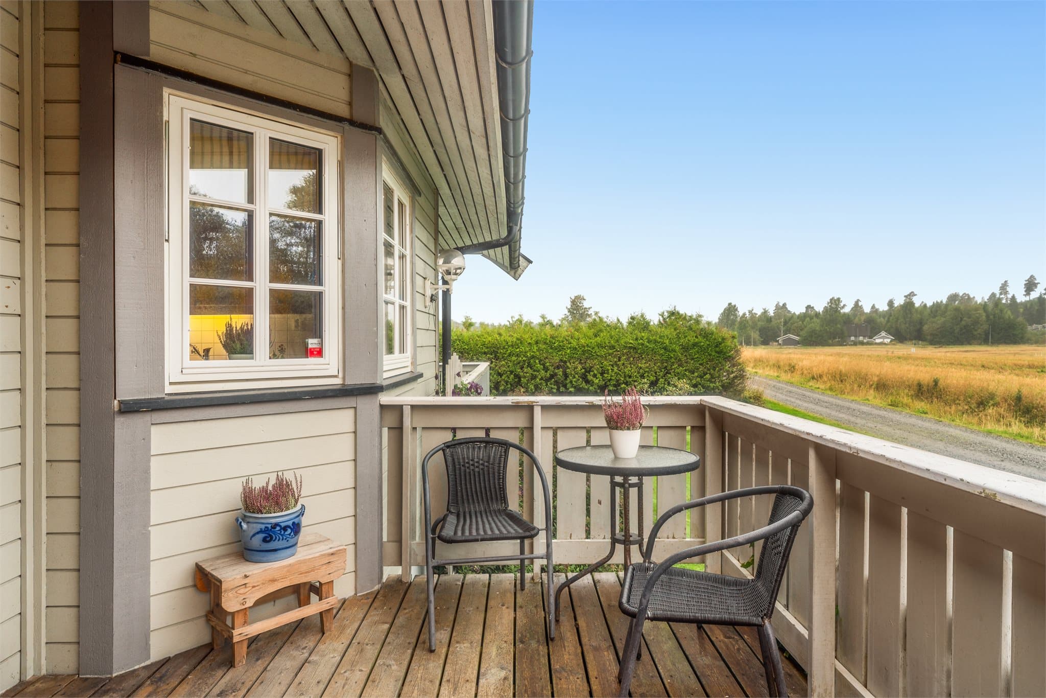 Overbygd entréveranda ved inngangspartiet med plass til kafésett.