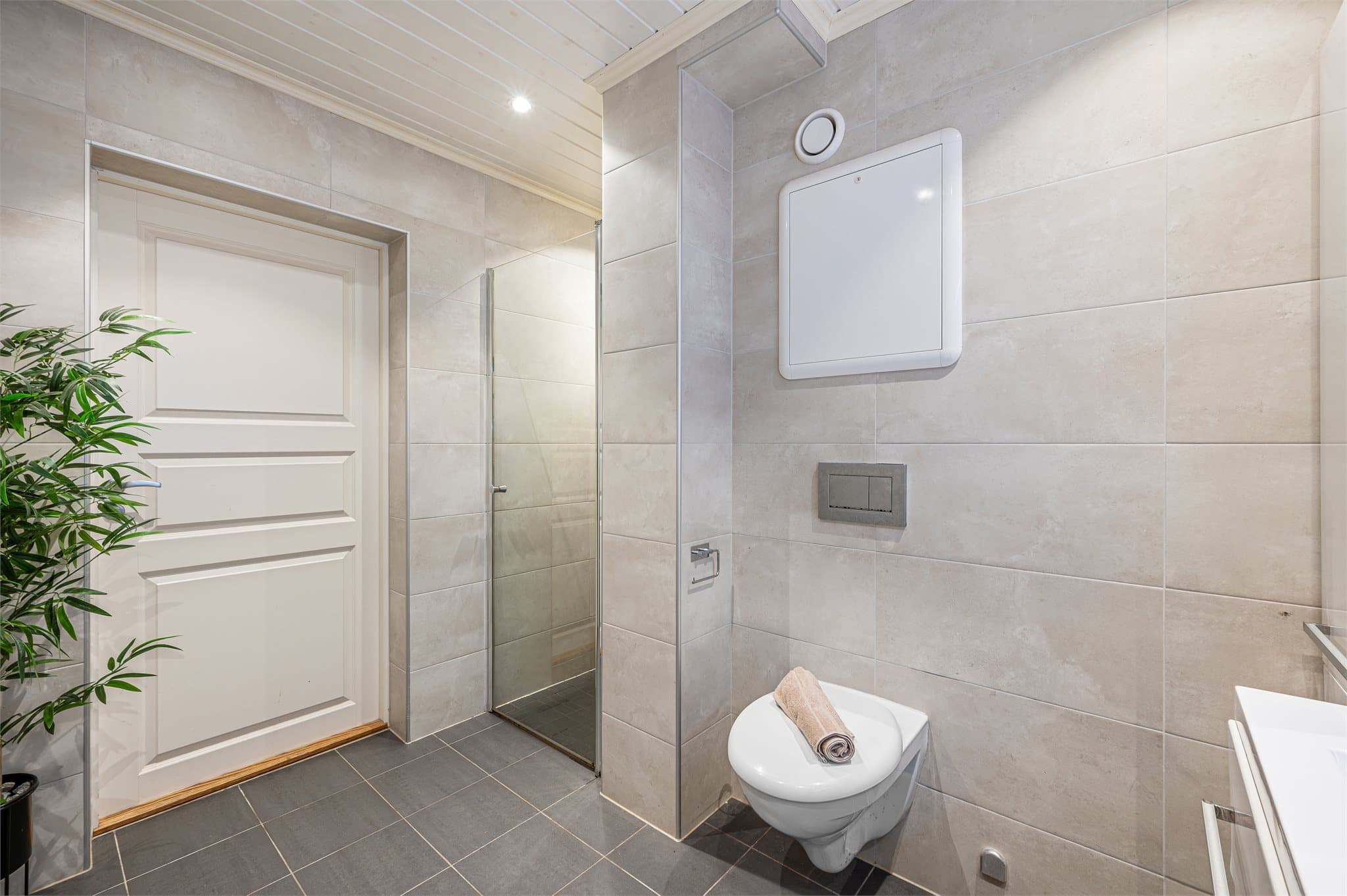 - Badet er innredet med vegghengt toalett, heldekkende servant og dusjnisje -