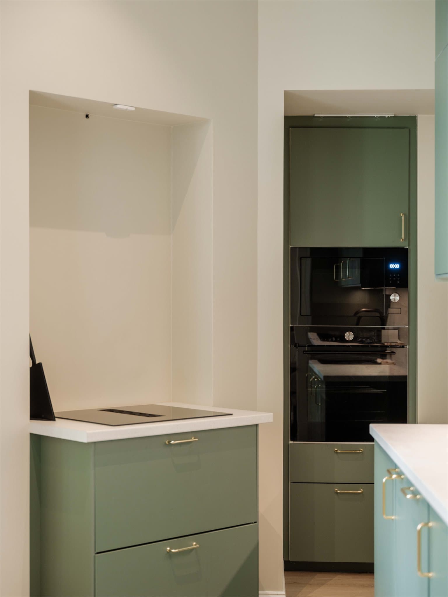 Stilrent kjøkken med et moderne og karakterfullt uttrykk. De glatte, grønne frontene kombineres med laminat benkeplate, nedfelt komposittkum og integrert LED-belysning under overskapene.