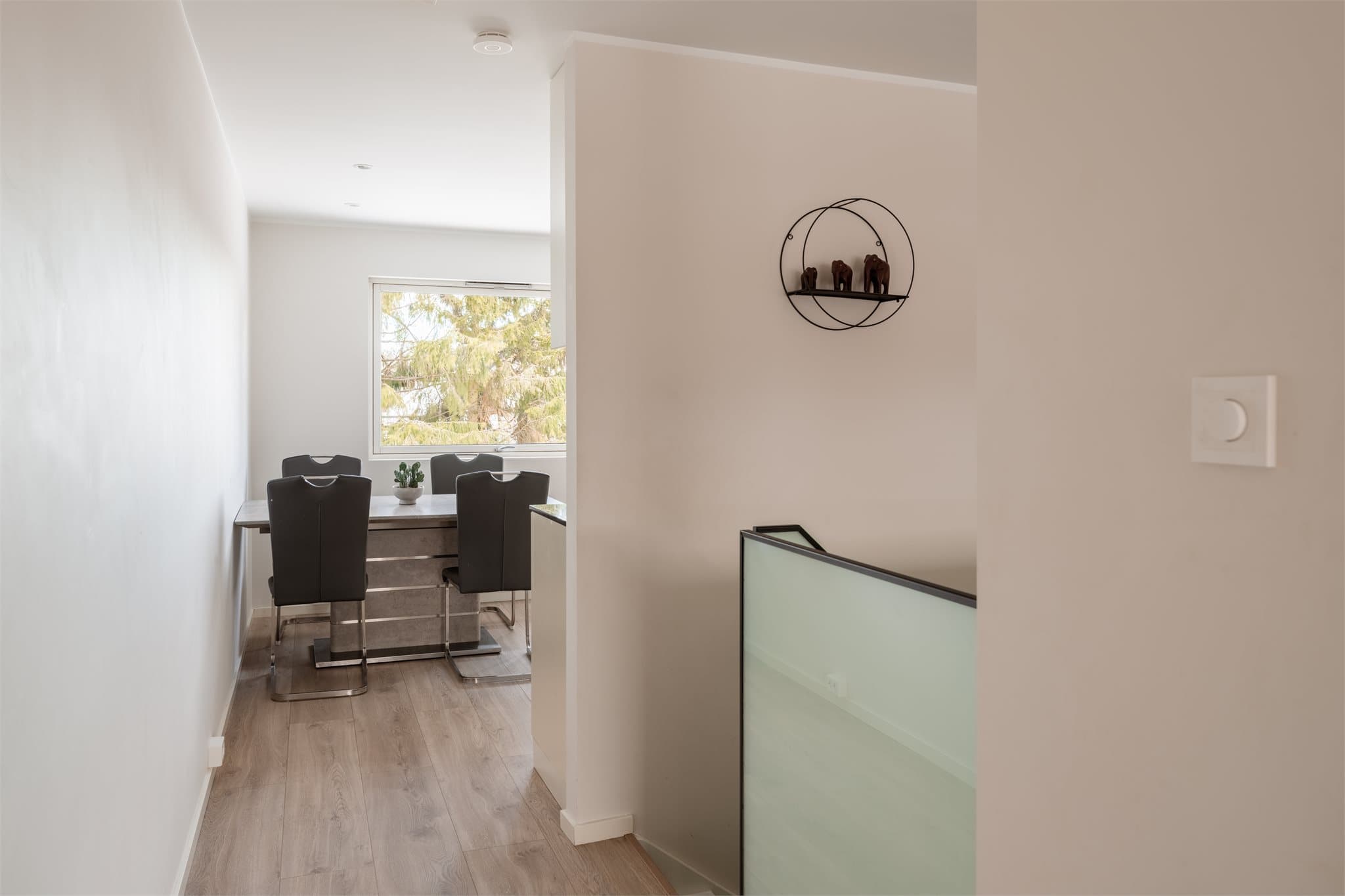 Fra trappen kommer man direkte inn i den sosiale sonen med kjøkkenet i front.