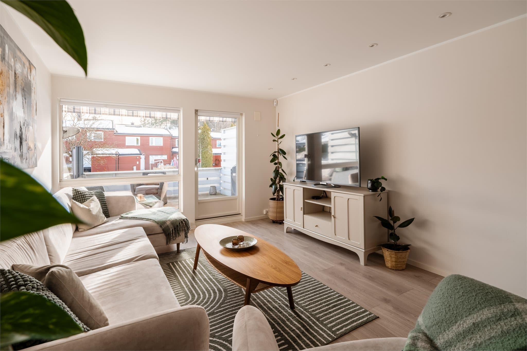 Store vinduer og balkongdør gir rikelig med naturlig lys.