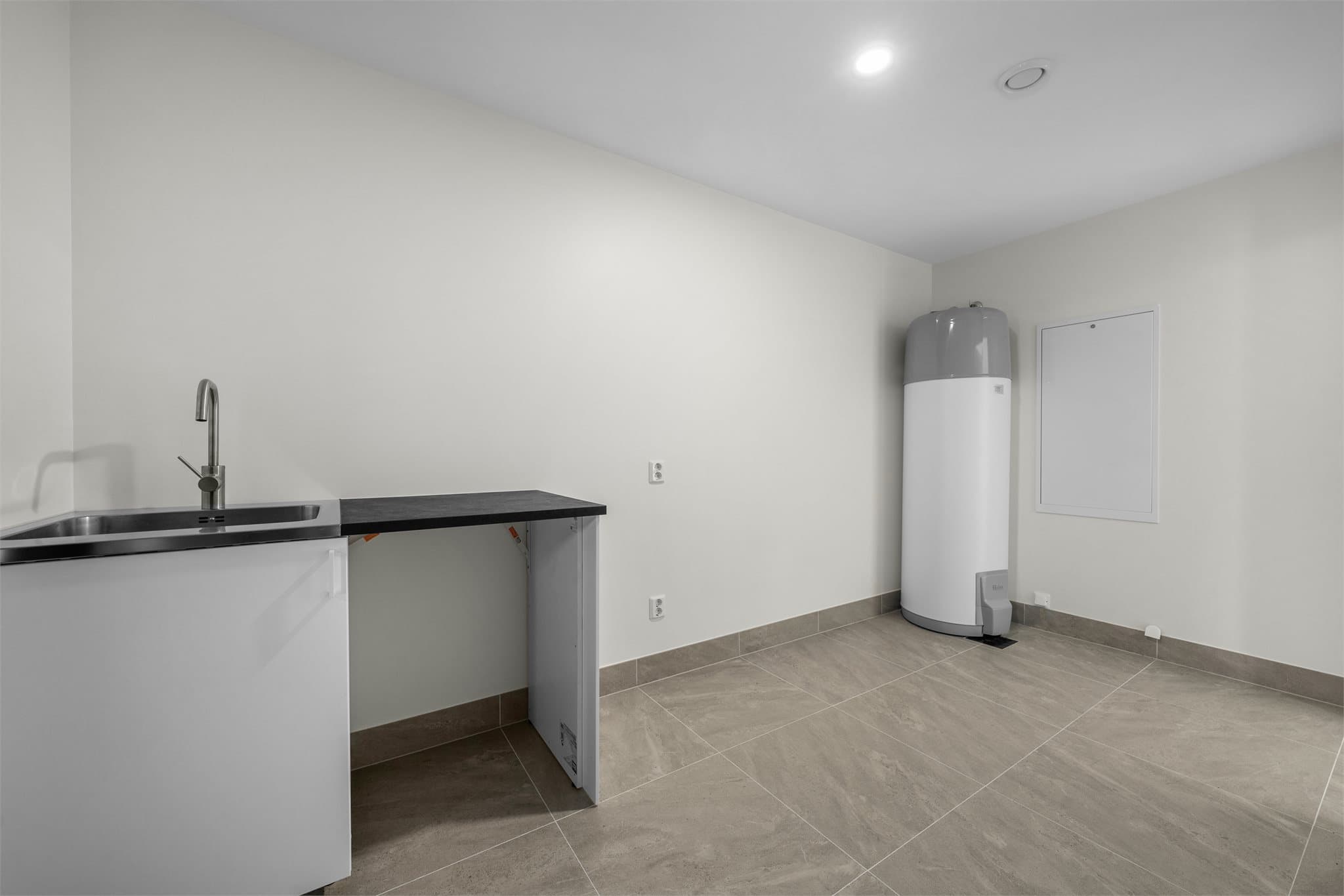 Praktisk separat vaskerom med fliser og varme i gulv