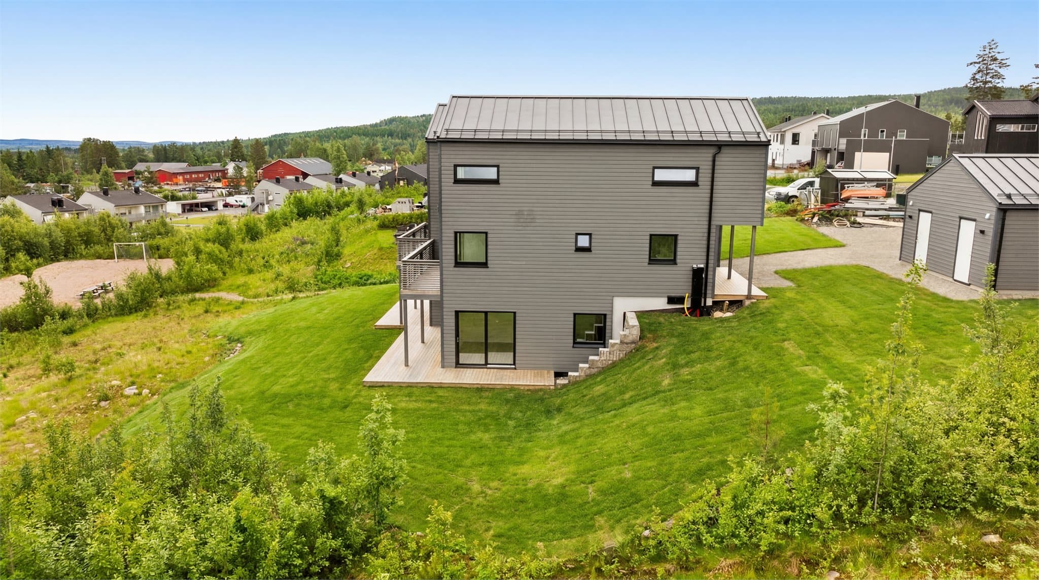Fasade hageside. Det er stor hage og terrasse. Bilder er digitalt redigert - og avvik kan dermed forekomme. Plen er sådd men pt. ikke grønt.