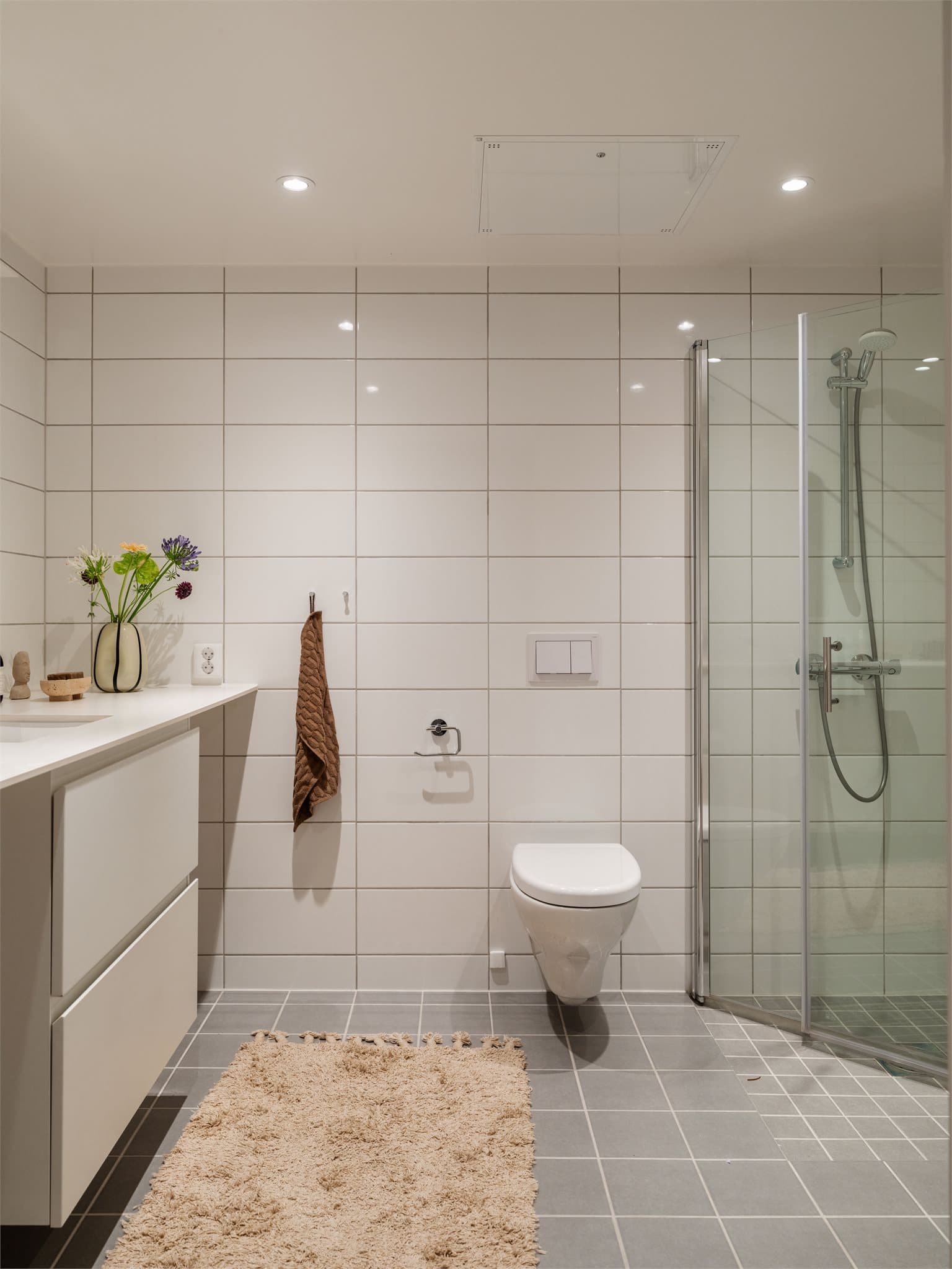 Badet har vegghengt toalett, downlights i taket og opplegg for vaskemaskin.