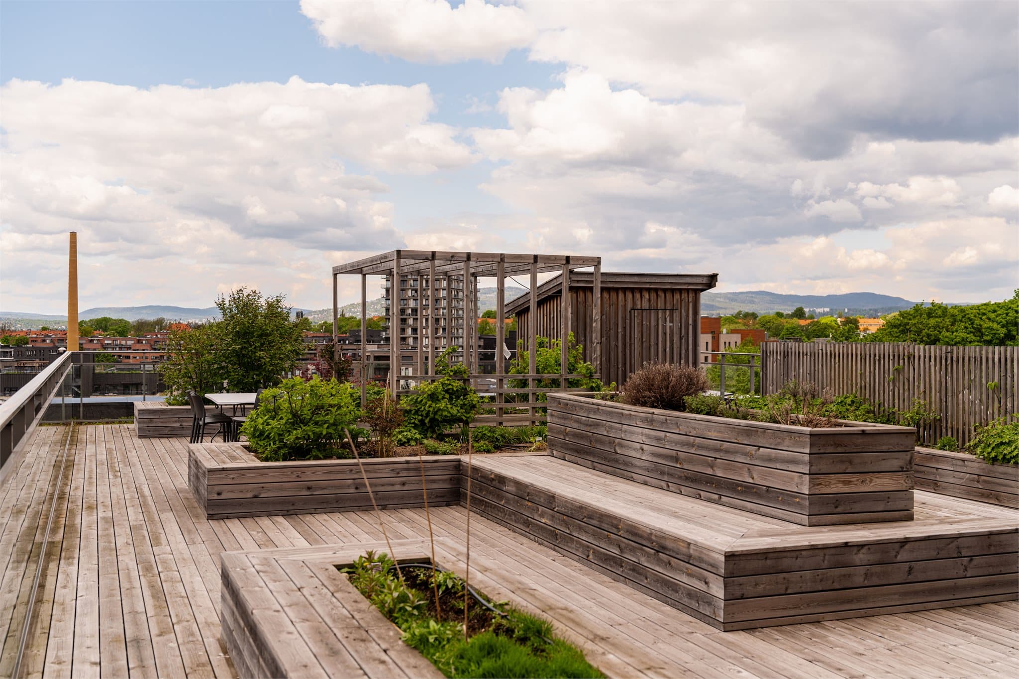 Terrassene er pent opparbeidet med plantekasser, pergola og flere sittegrupper.